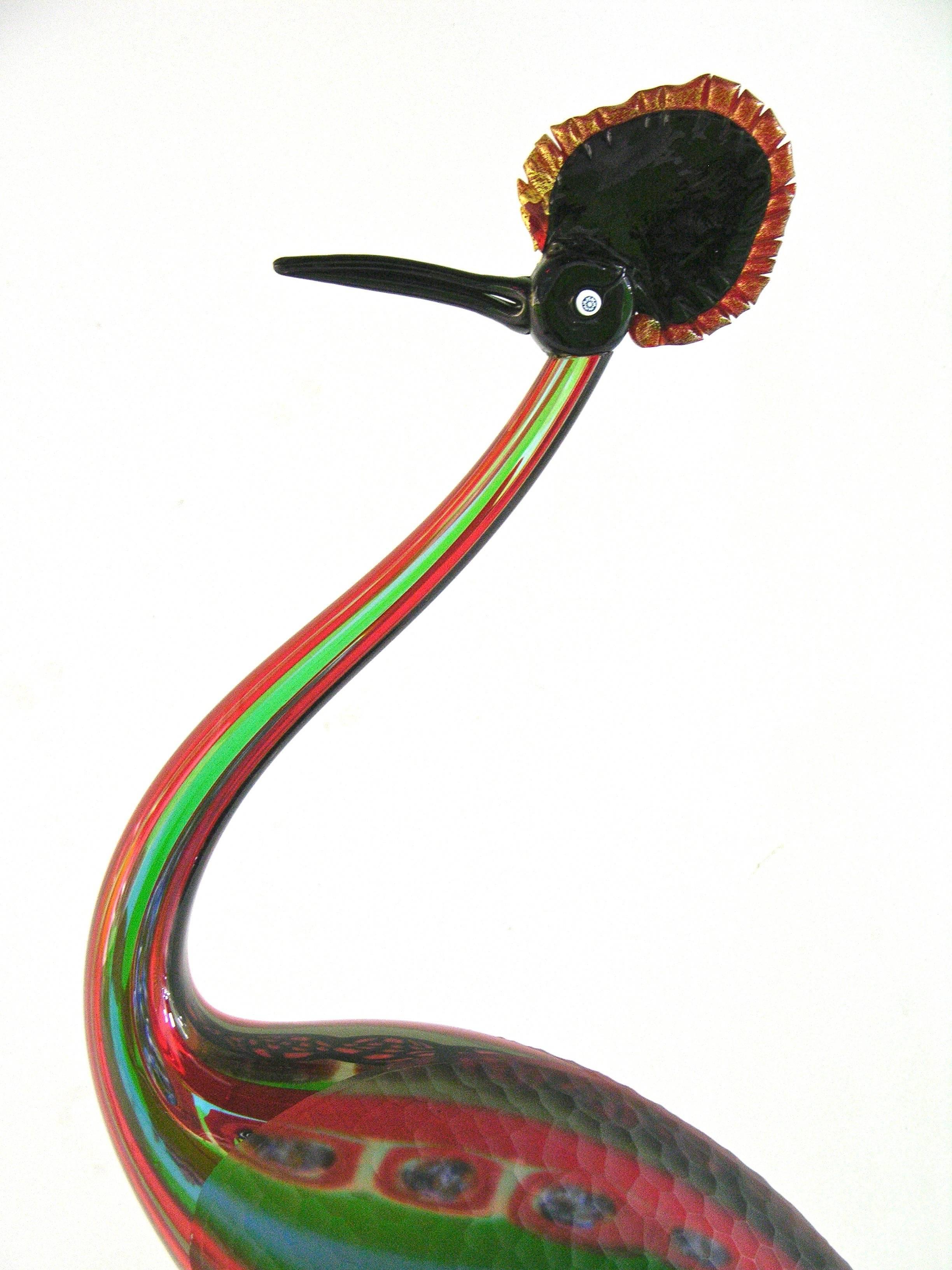 This very expressive crested crane art glass sculpture, from the 1970s, is a true jewel-like work of art, in sophisticated blown Murano glass, with overlaid stripes decor in red, blue and green, with inserted multi colored murrine and part of the