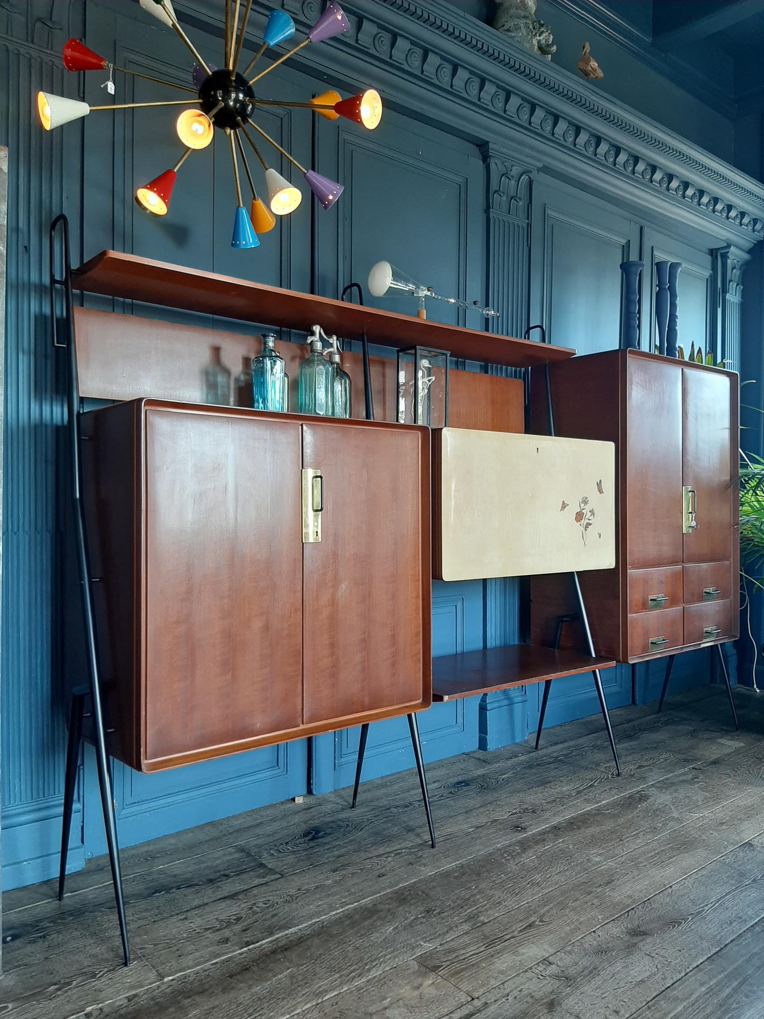 Vintage Italian livingroom furniture by Silvio Cavatorta with bar cabinet, storage space, bookshelves and bar. This Mid-Century Modern design wall unit / sideboard /buffet /bookcase is made in the 1960s. Made of teak veneerd wood, with brass handles