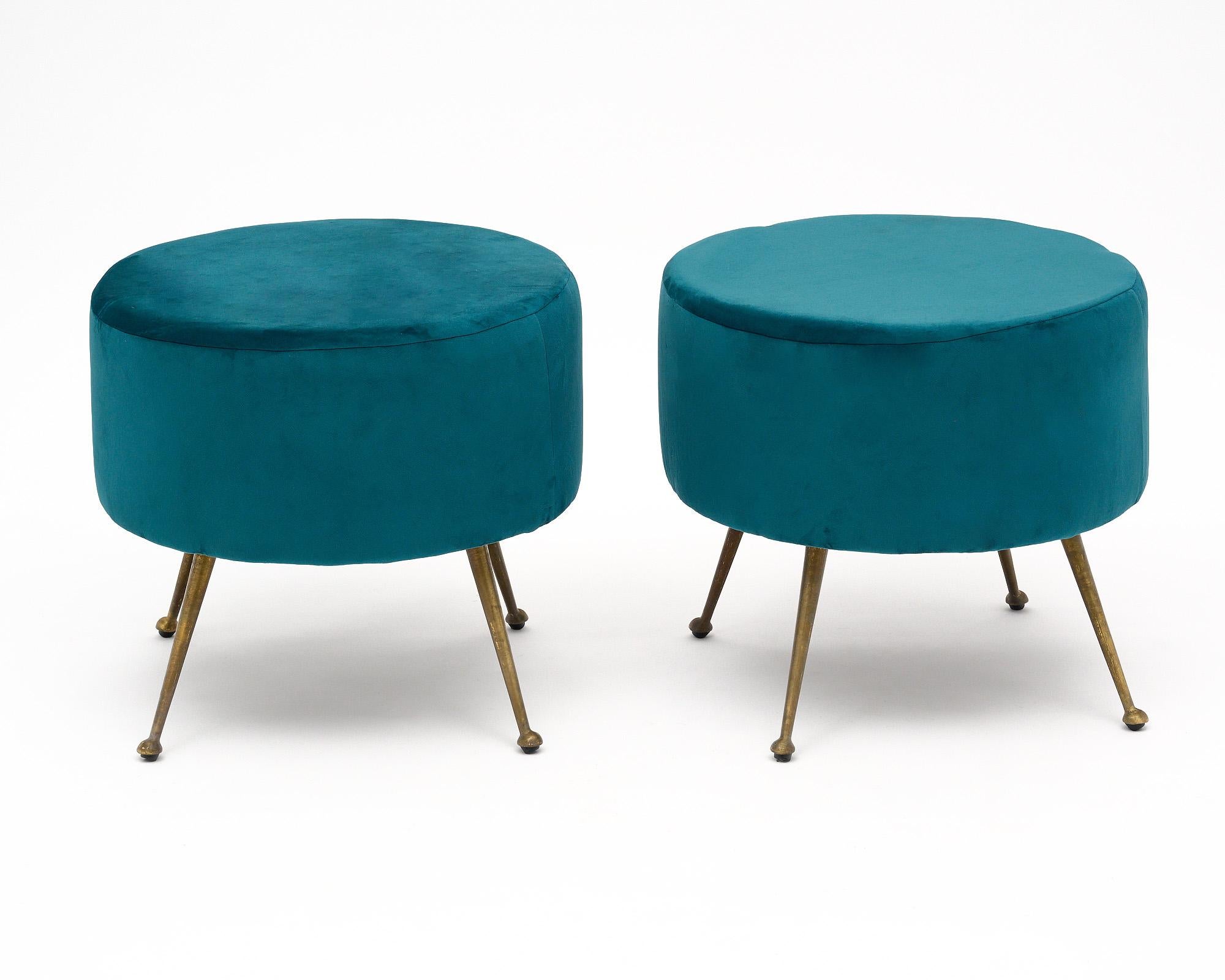 Pair of Italian mid-century modern stools that have been newly upholstered in a teal colored micro fiber. Four original tapered, flared brass legs support the seat.
