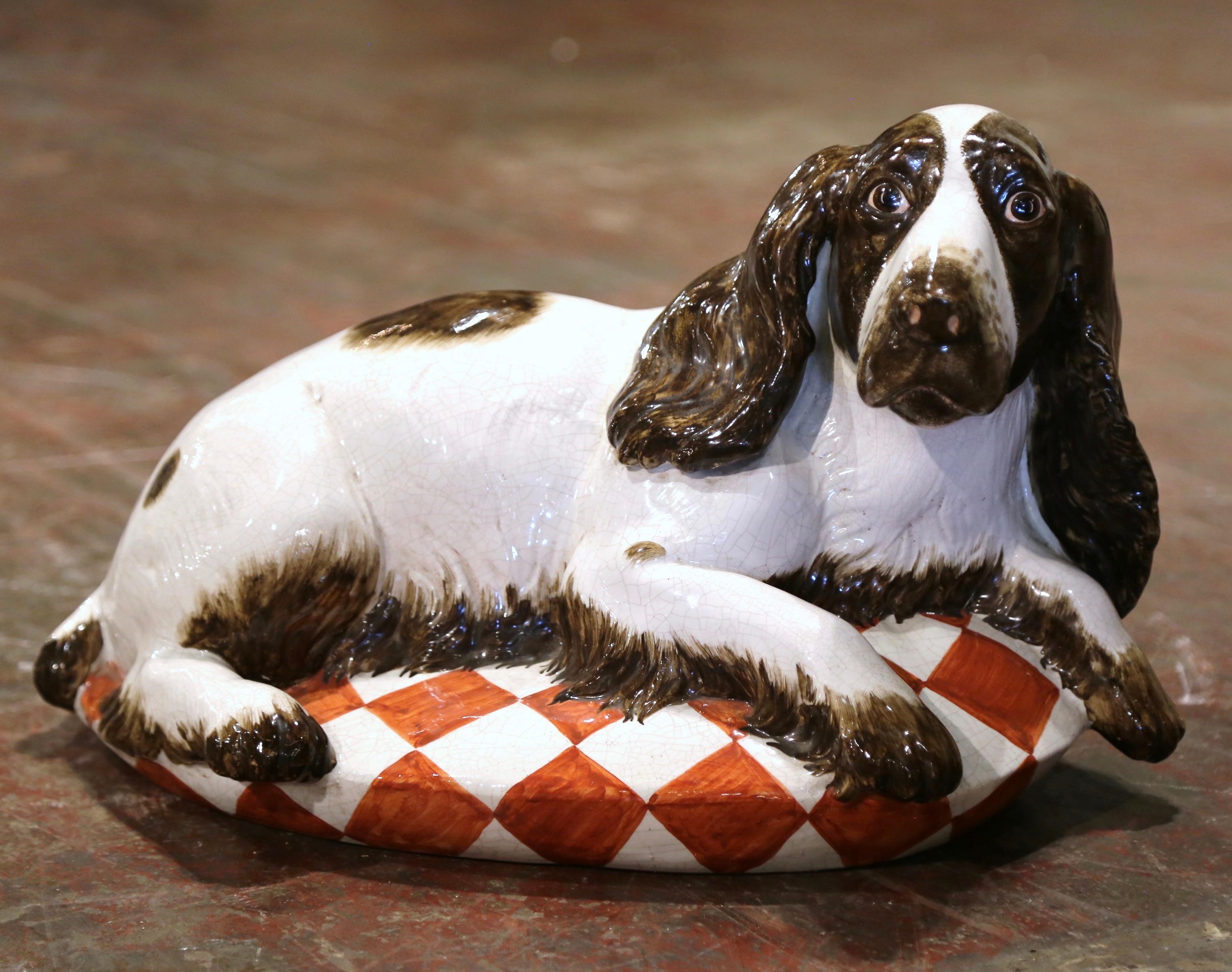 Dog lovers will appreciate this realistic vintage hound dog. Crafted in Italy, circa 2000, this charming terracotta statue is life-size, and depicts a sitting basset hound resting on a checker pillow. Boasting lovely russet, brown and white colors