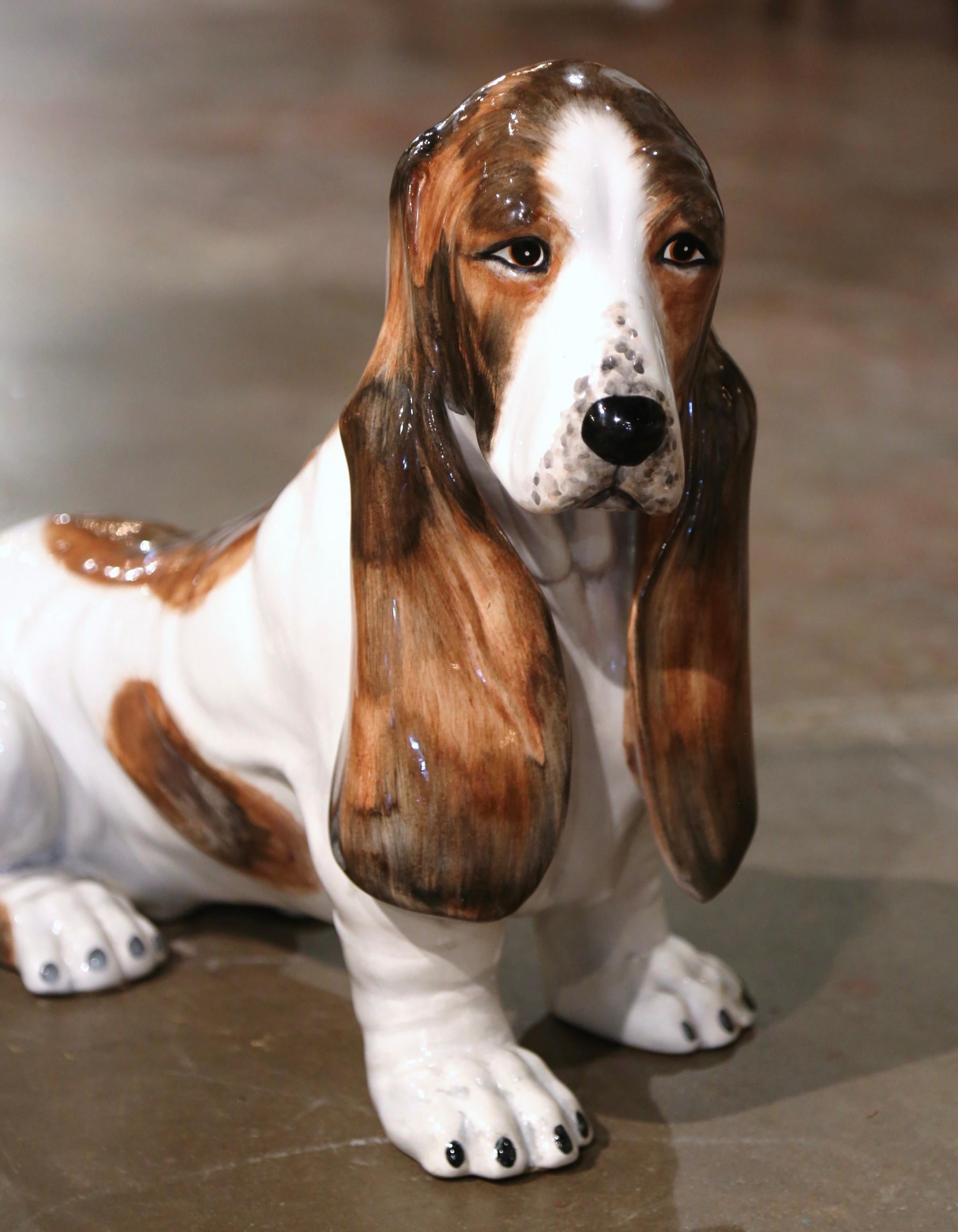 Dog lovers will appreciate this realistic vintage hound dog. Crafted in Italy, circa 2000, this charming terracotta statue is life-size, and depicts a large basset hound with long droopy ears sitting at attention. Boasting lovely russet, brown and