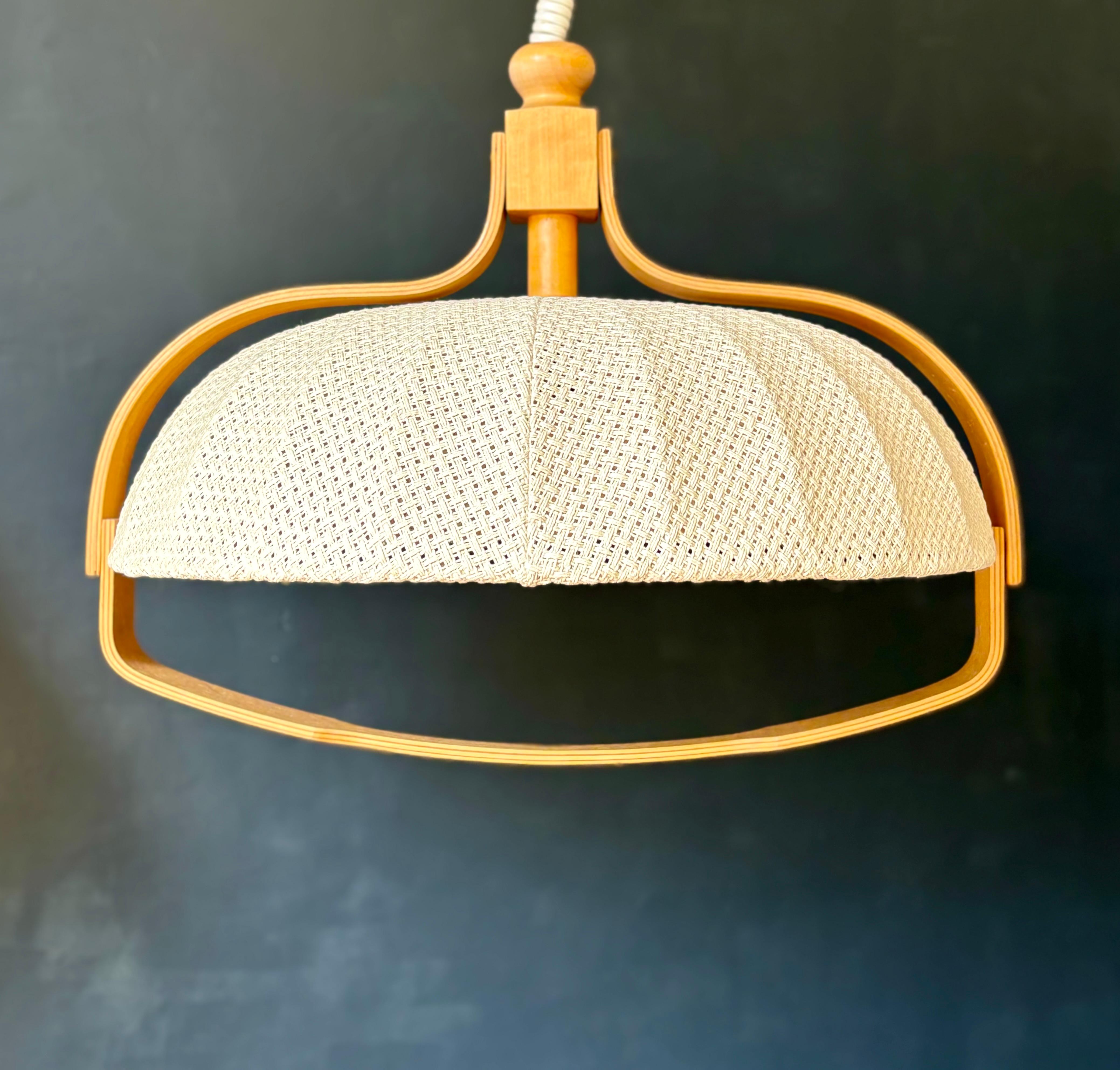 Pendente vintage moderno italiano con paralume in tessuto intrecciato color sabbia chiaro a forma di cupola su un sottile supporto in legno curvato laccato. Il raccordo è contrassegnato da Rolly Brevettato e il ciondolo è progettato nello stile