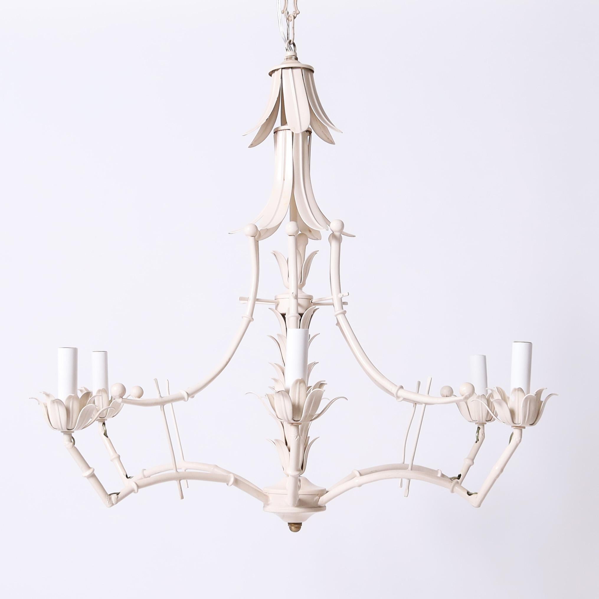 In vogue mid century six light chandelier crafted in metal in a regency style with a bit of whimsy, using faux bamboo and acanthus leaves and having the original off white finish. 