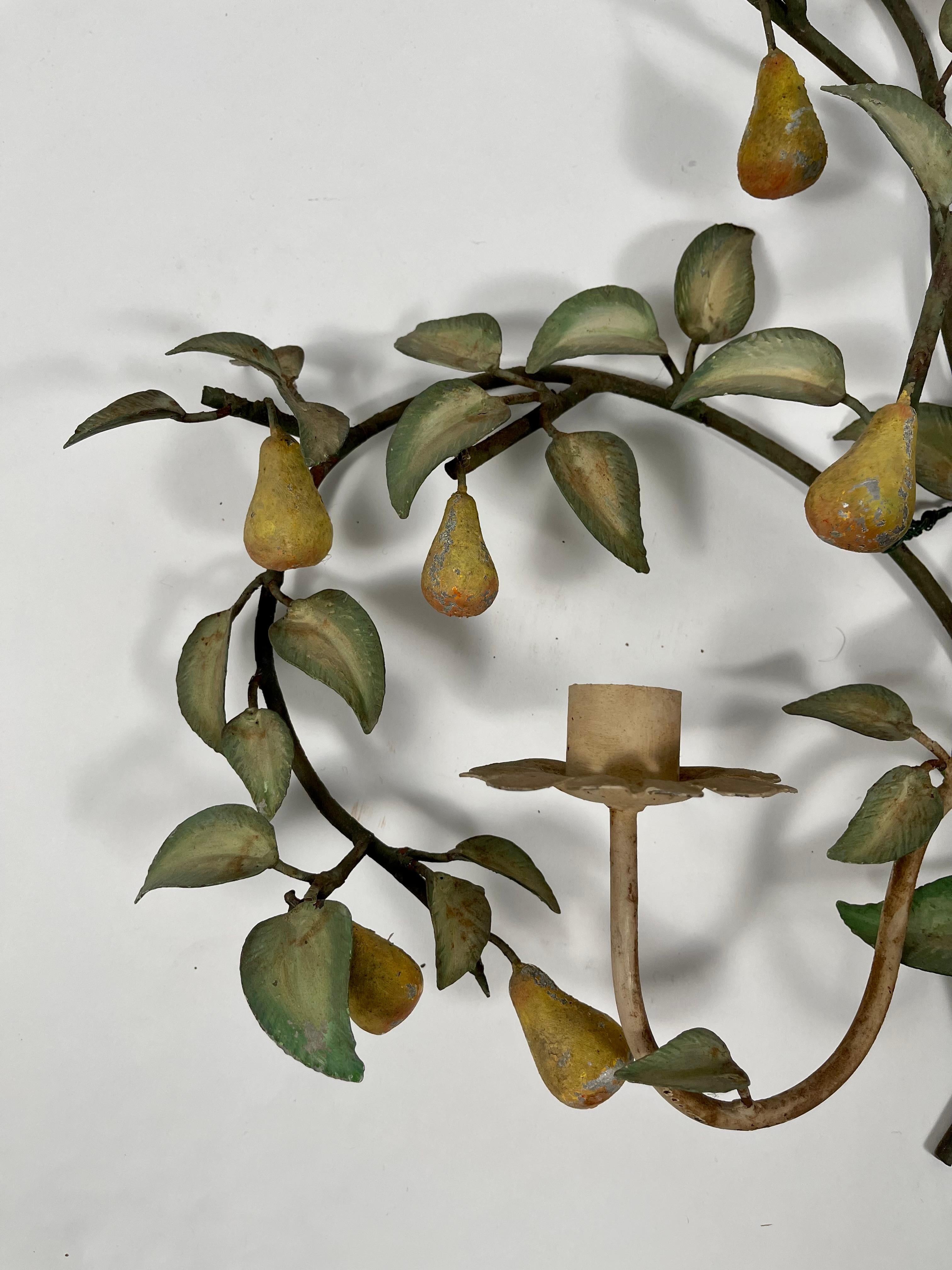 A vintage Italian tole pear tree three light wall sconce decoration. Beautifully designed and made in the form of a pear tree with variegated green leaves and meandering branches, this sconce can be used for candlelight or perhaps electrified.