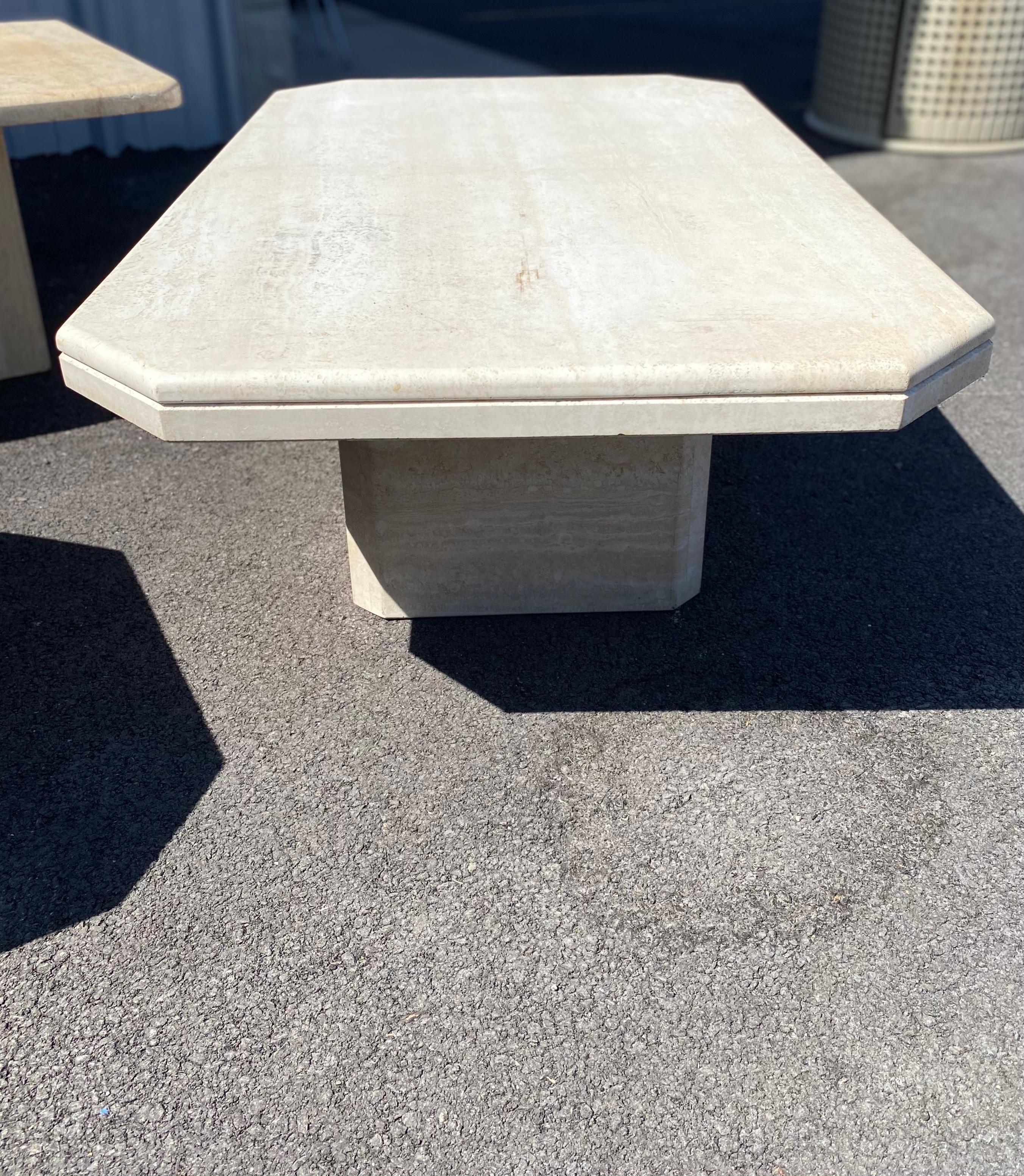 Elegant vintage Italian travertine coffee table circa early 1980s. The coffee table comes in two pieces, pedestal and table top. The table top features carved edges and is in good vintage condition. Color is of a lighter travertine variant. There