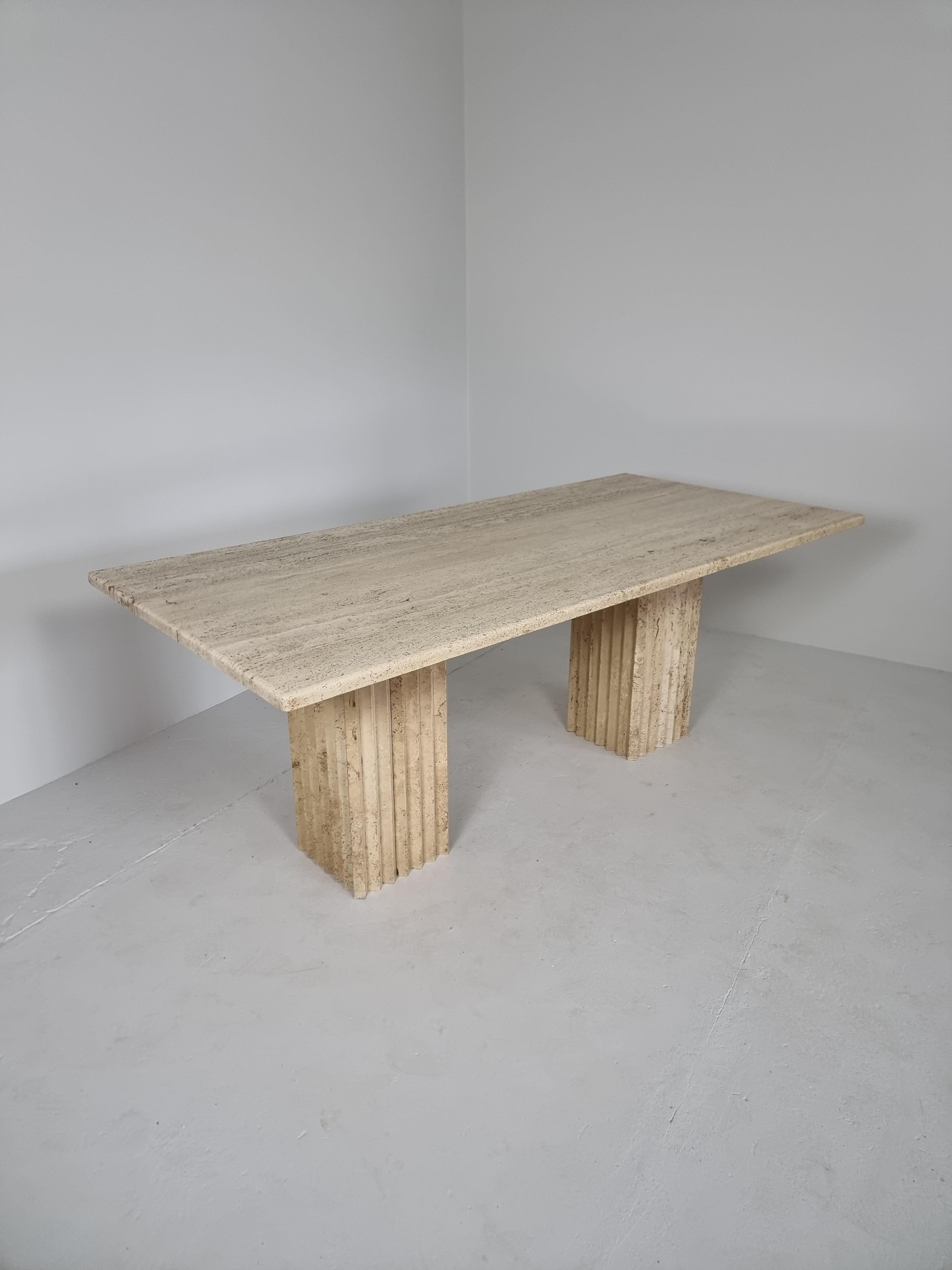 Postmodern piece in travertine marble that can be used as a writing desk or dining table. Fits 6 to 8 persons.

The two impressive columns are not attached to the table, these can be placed freely underneath the top.

You could also turn them