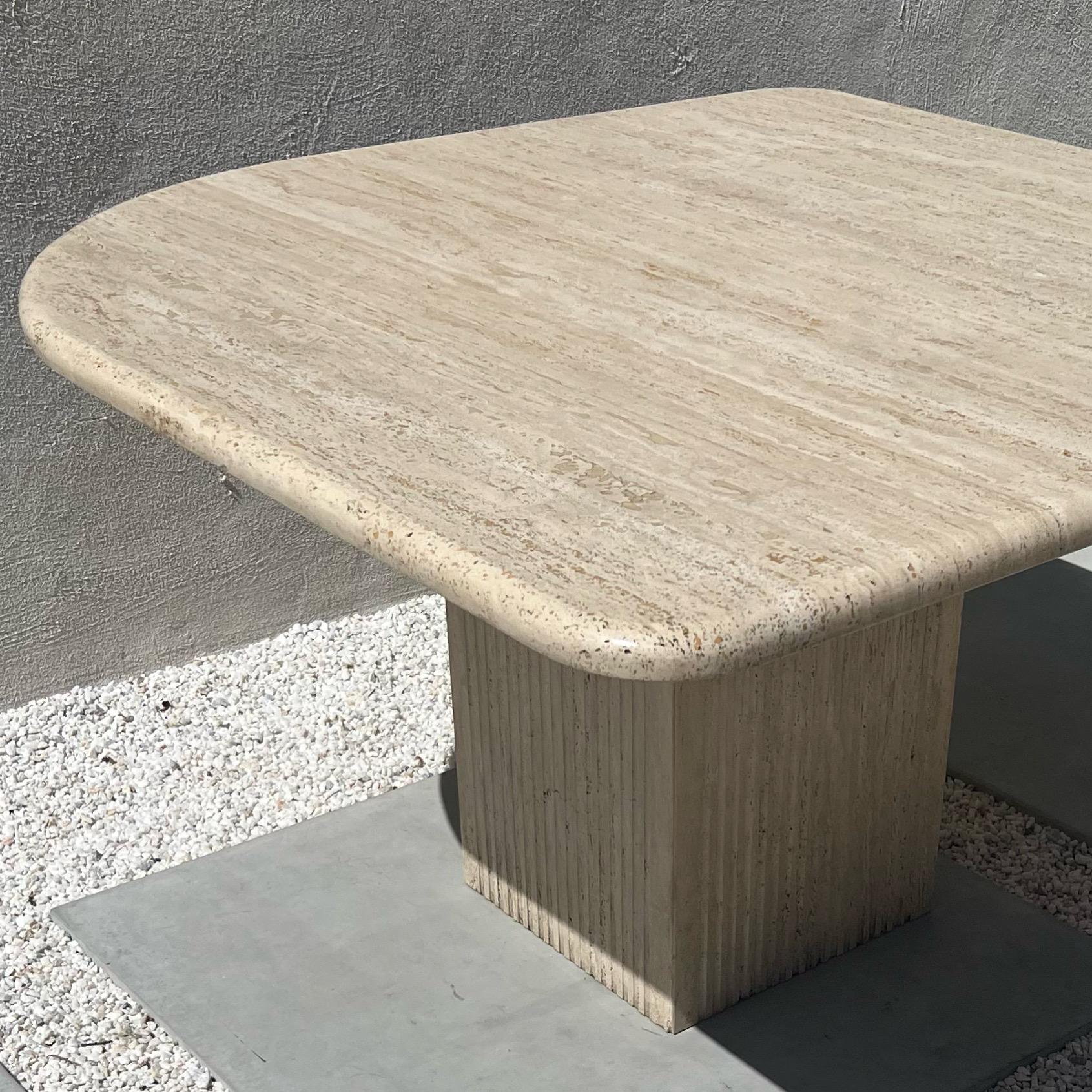 An extraordinarily rare eye-shaped travertine dining table with pleated pedestal base, circa 1970. Made in Italy of glorious thick, raw travertine. Seats four spaciously, and up go eight (albeit a bit squished!). I believe this is the original