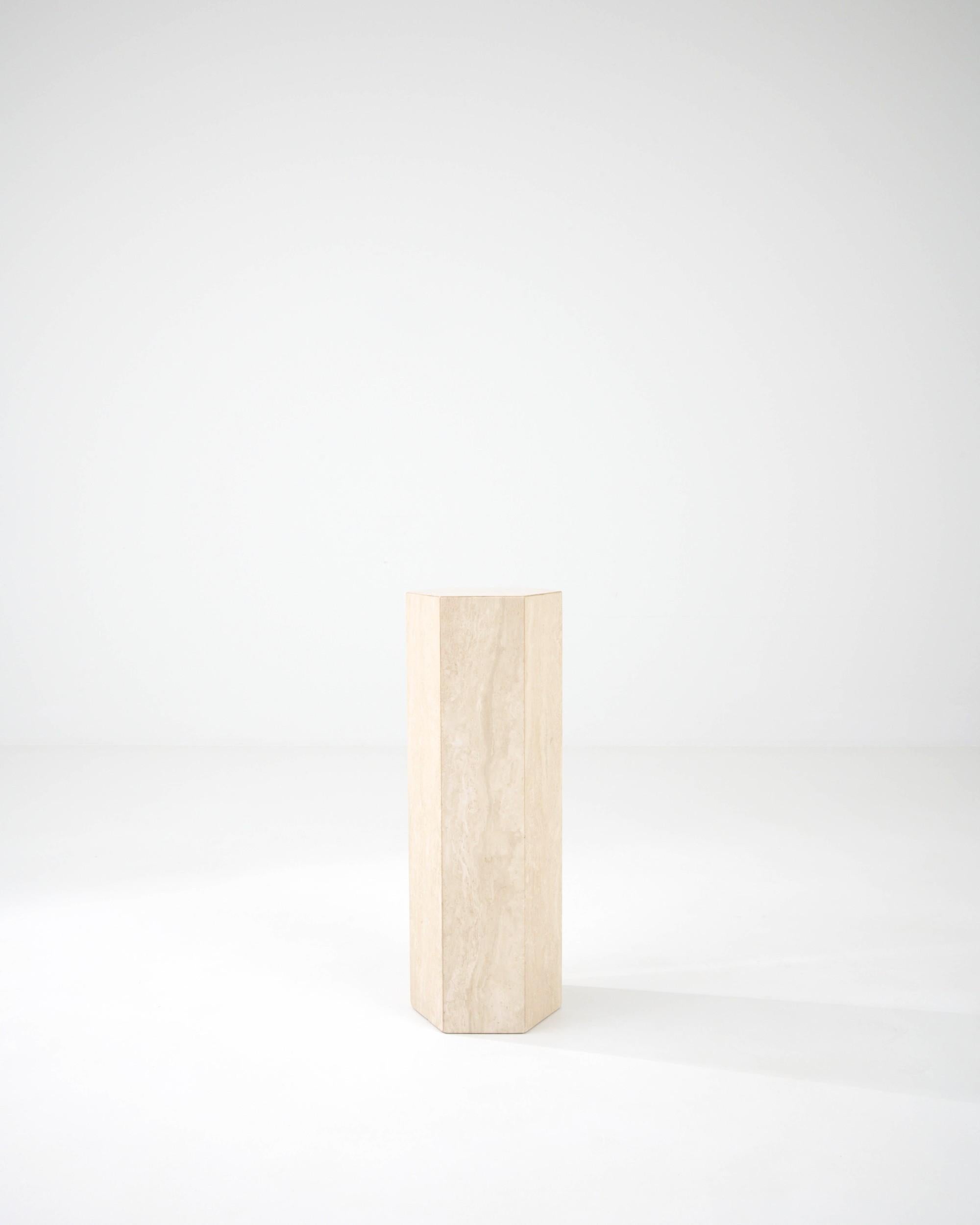 A marble pedestal made in 20th Century Italy. Elegant and understated, this stone pedestal makes an ideal base for elevating your favorite collectible. The minimal shape and neutral color have an unparalleled versatility, while the lavish travertine