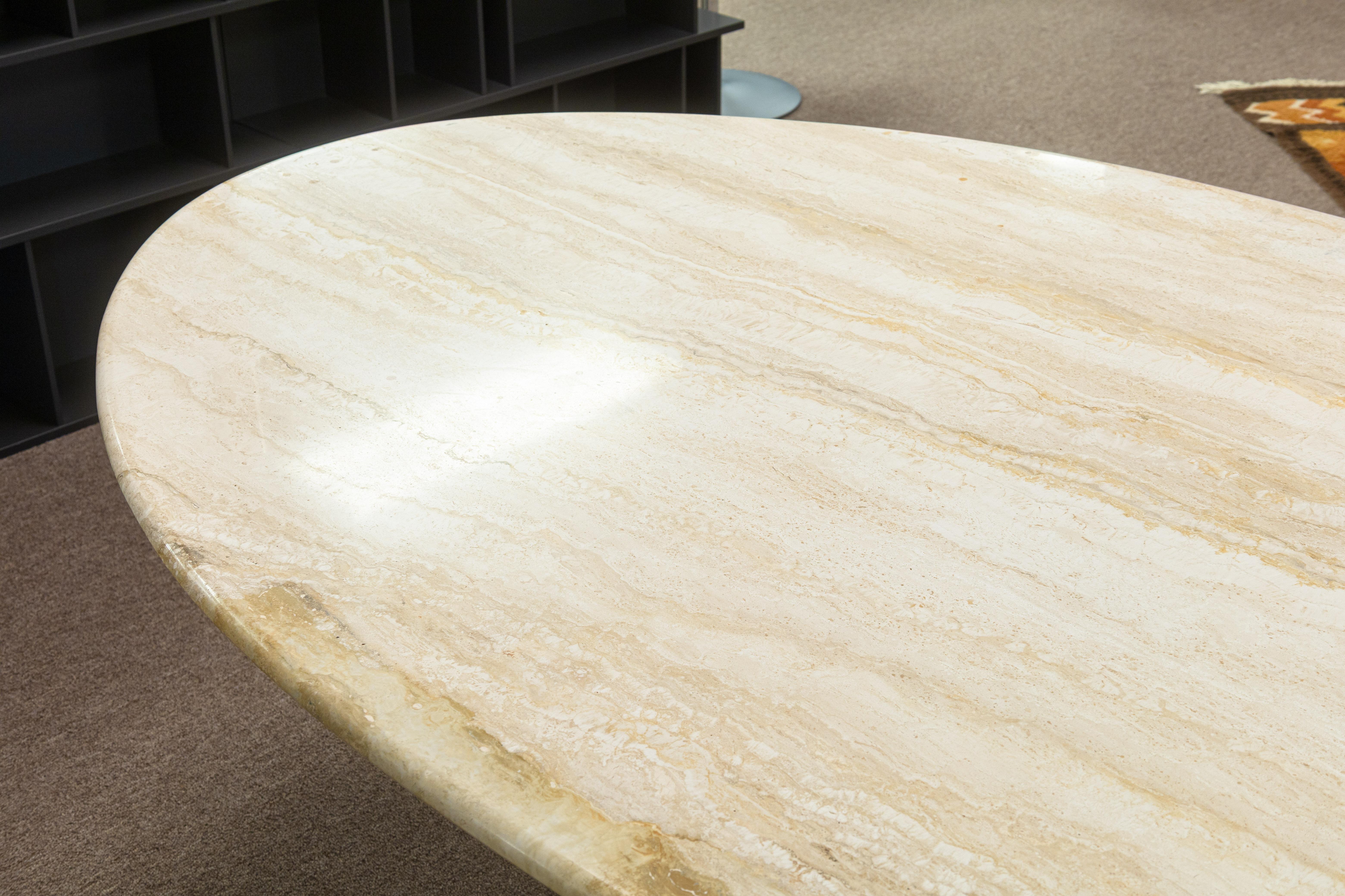 A vintage Italian travertine stone dining table. This is a gorgeous vintage dining table featuring a classic travertine stone construction, popular in the 70s and even hotter now. This table has a large oval table top with rounded edges, and sits