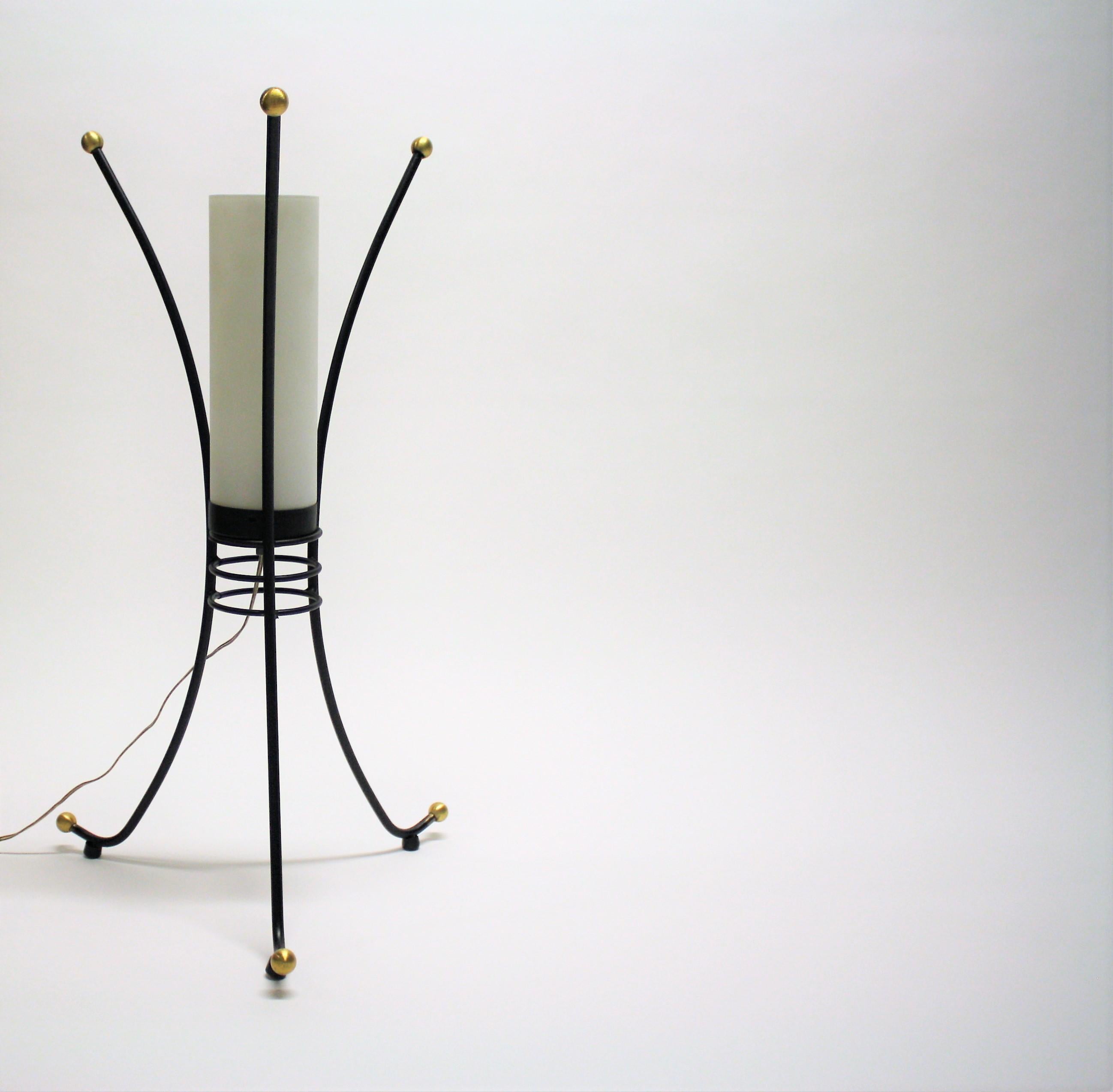 Charming tripod design mid century table lamp with a milk glass lamp shade.

The lamp has golden feet and tops.

Designer unknown.

The lamp can be used as a small floor lamp or as a large table lamp.

It emits a warm and welcoming