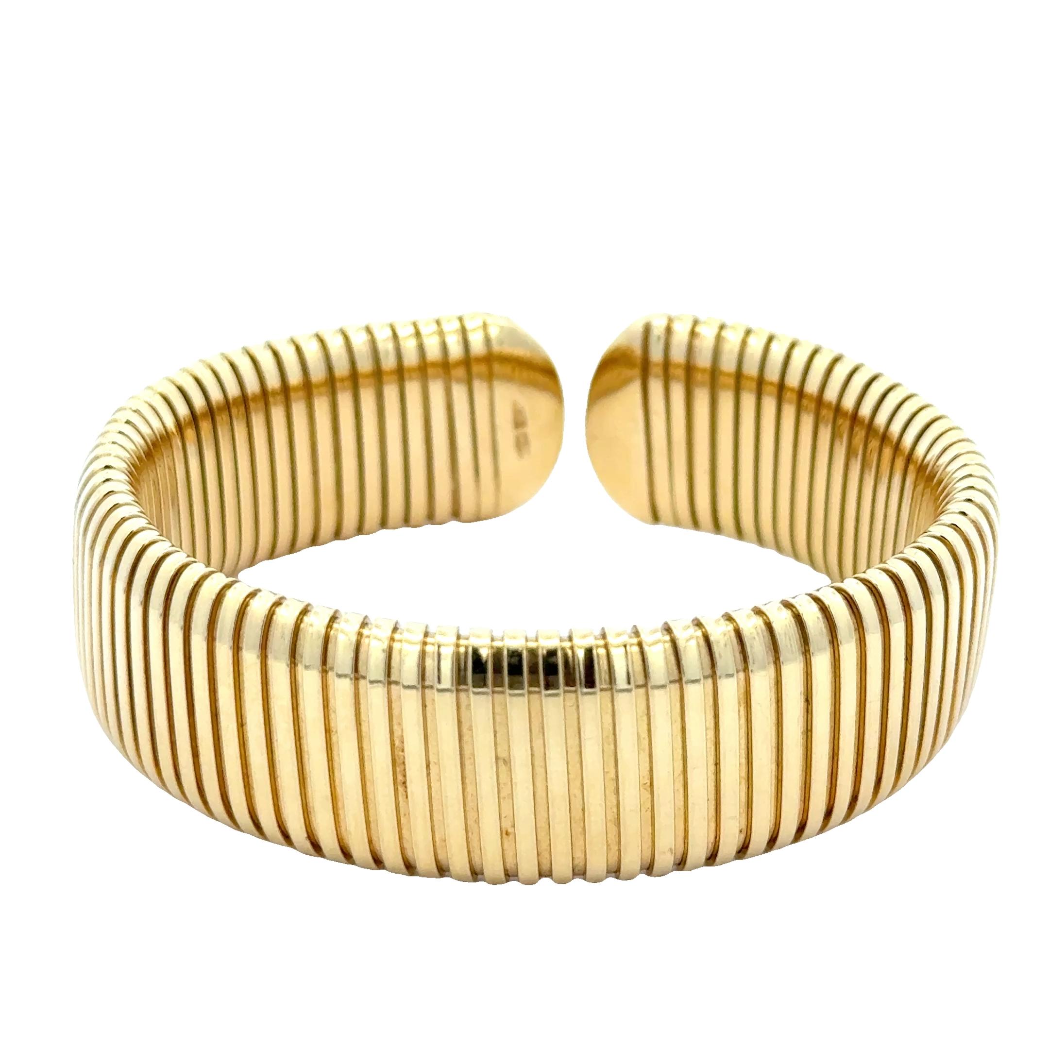 Hommage lumineux à l'art italien, ce bracelet manchette Tubogas vintage est délicatement réalisé en or jaune 18 carats, mettant en valeur l'élégance fluide et enroulée de l'emblématique technique Tubogas. Avec sa forme souple et serpentine et sa