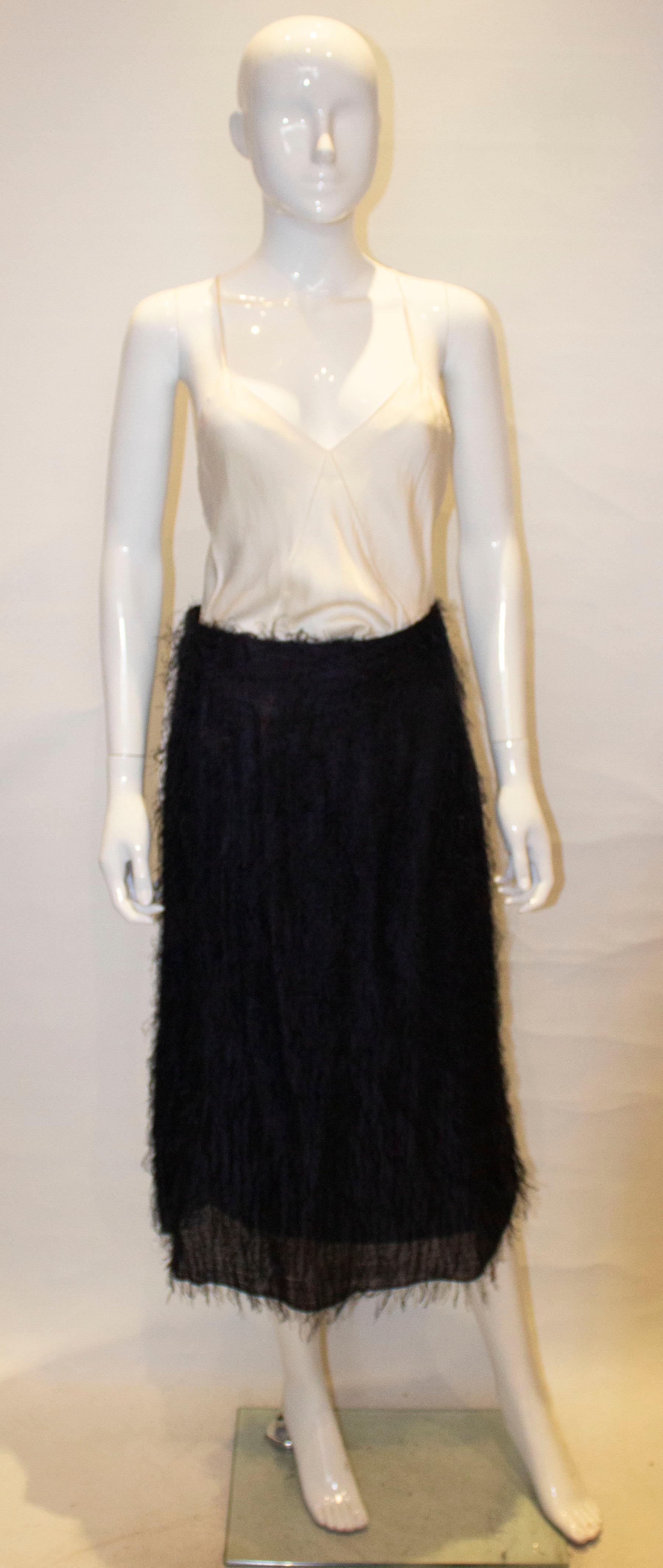 A chic vintage skirt covered in soft tufts. The skirt is fully lined and has a side zip opening.