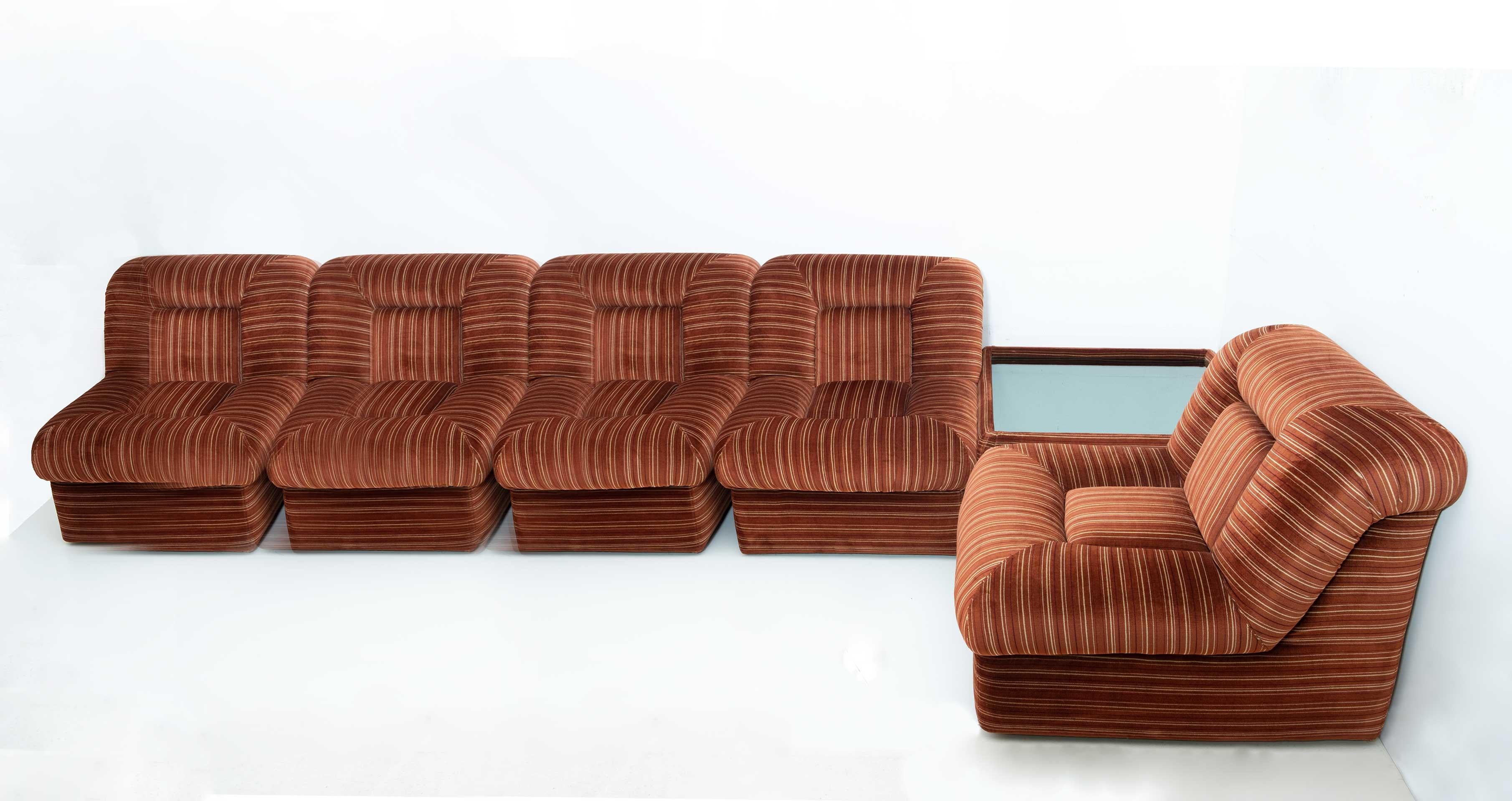 Beautiful velvet modular sofa, consisting of 5 armchairs and a coffee table.
The coffee table has a smoked mirror as a top.
The Italian sofa is in dark orange hammered velvet, original from the period, in good condition, as shown in the photos. Its