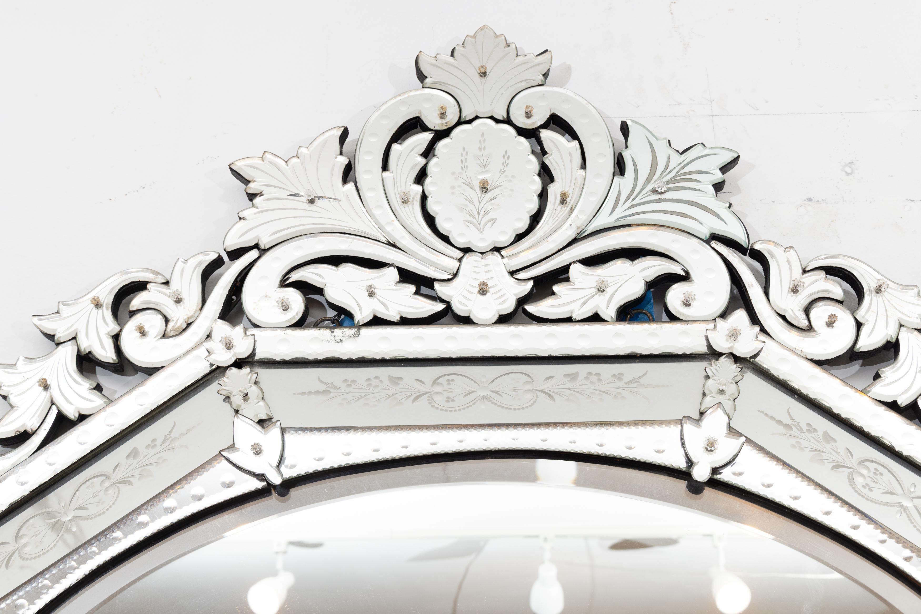 This is a unique vintage Italian Venetian mirror with an octagonal center plate surrounded by an etched conforming frame.  The mirror’s aesthetic is enhanced by an ornate etched foliate cornice and matching apron.