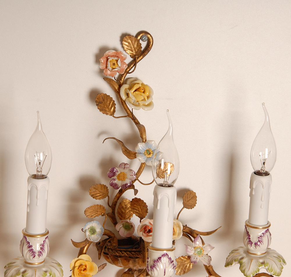 A pair Italian Gold Florentiner 2 light wall sconces with porcelain roses and bobeches. 
The porcelain roses are hand crafted and hand painted in pale colours.
as pale yellow and pale pink and also the bobeches which are usually made of tole