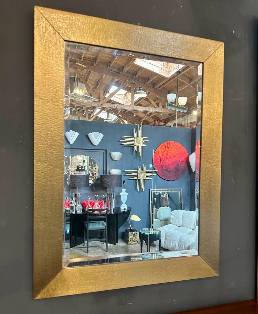 The square vintage Italian wall mirror, designed by Aldo Frigerio and made in Italy in the 1980s, is a remarkable piece that combines retro charm with a touch of luxury. The mirror features a square shape and boasts a thick, 3-inch brass frame that