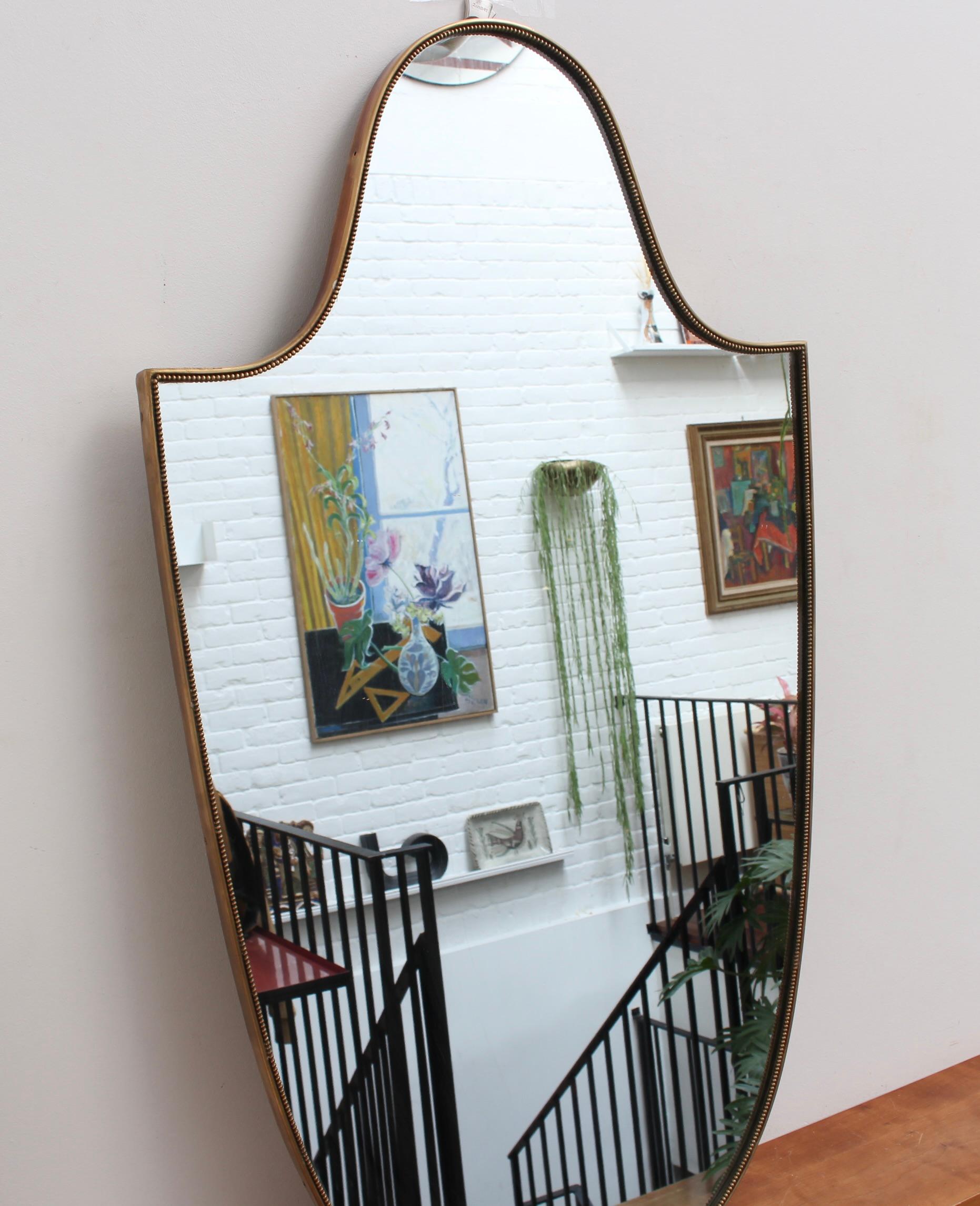 Large mid-century Italian wall mirror with brass frame (circa 1950s). This mirror is very substantial, solid and at once elegant. It is the Sophia Lauren of vintage mirrors with its incredible looks, charming personality and characterful beauty