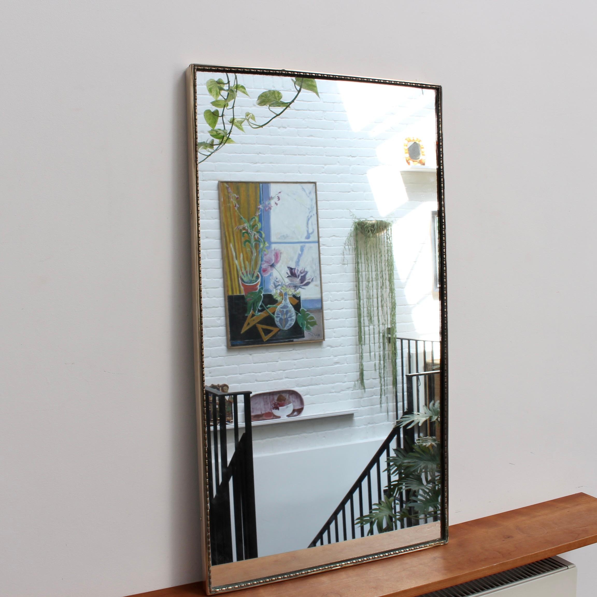 Mid-century Italian wall mirror with brass frame (circa 1950s). The mirror is large, rectangular in shape, smart and distinctive in a modern Gio Ponti style with a distinctive beading outlining the frame. This mirror is in good overall condition.