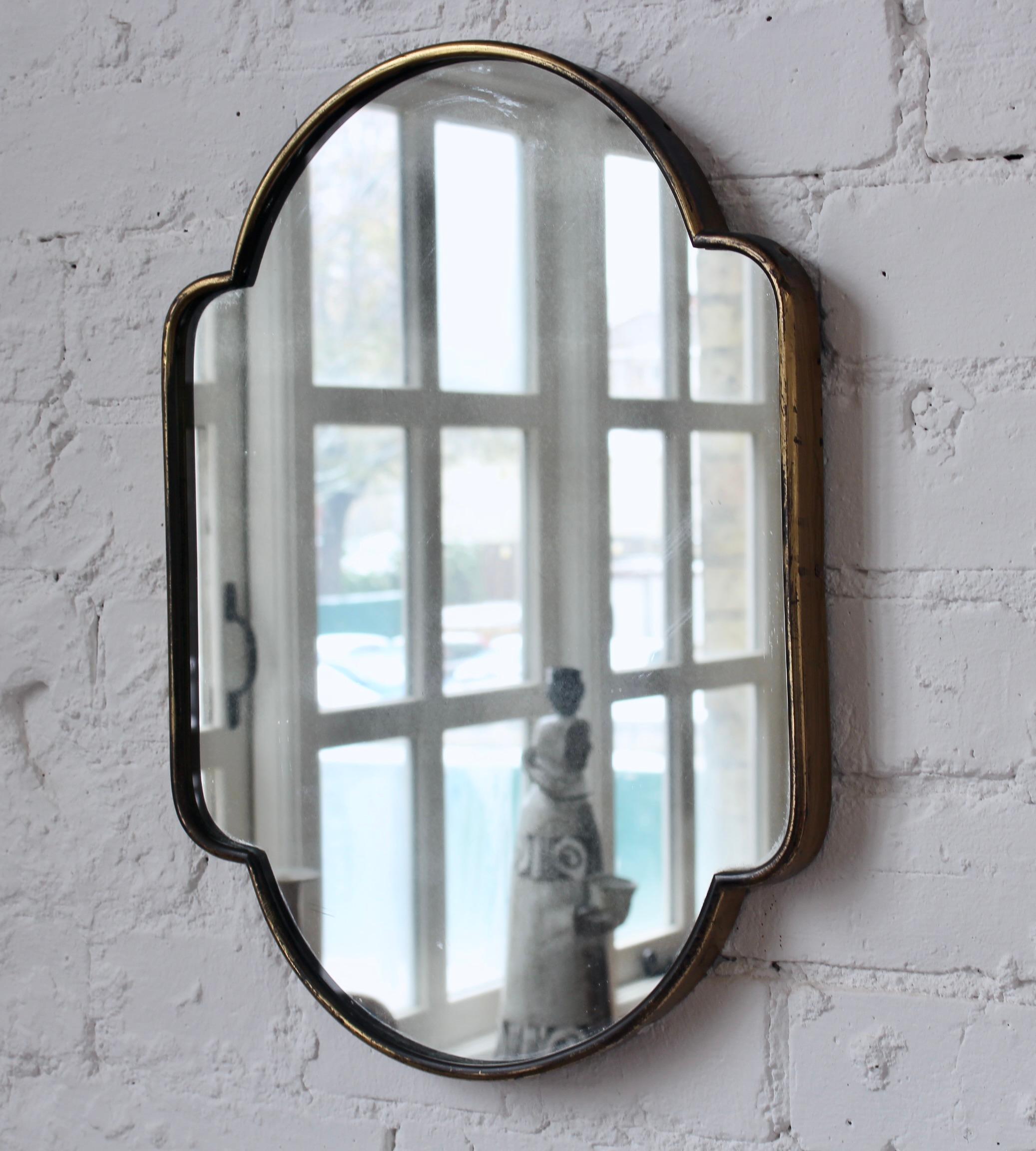 Small scale 'pill-shaped' vintage Italian wall mirror with brass frame (circa 1950s). The mirror has straight, rectangular-shaped sides but with a sensuous curve on top and on the bottom. It is classically elegant and distinctive in a modern Gio