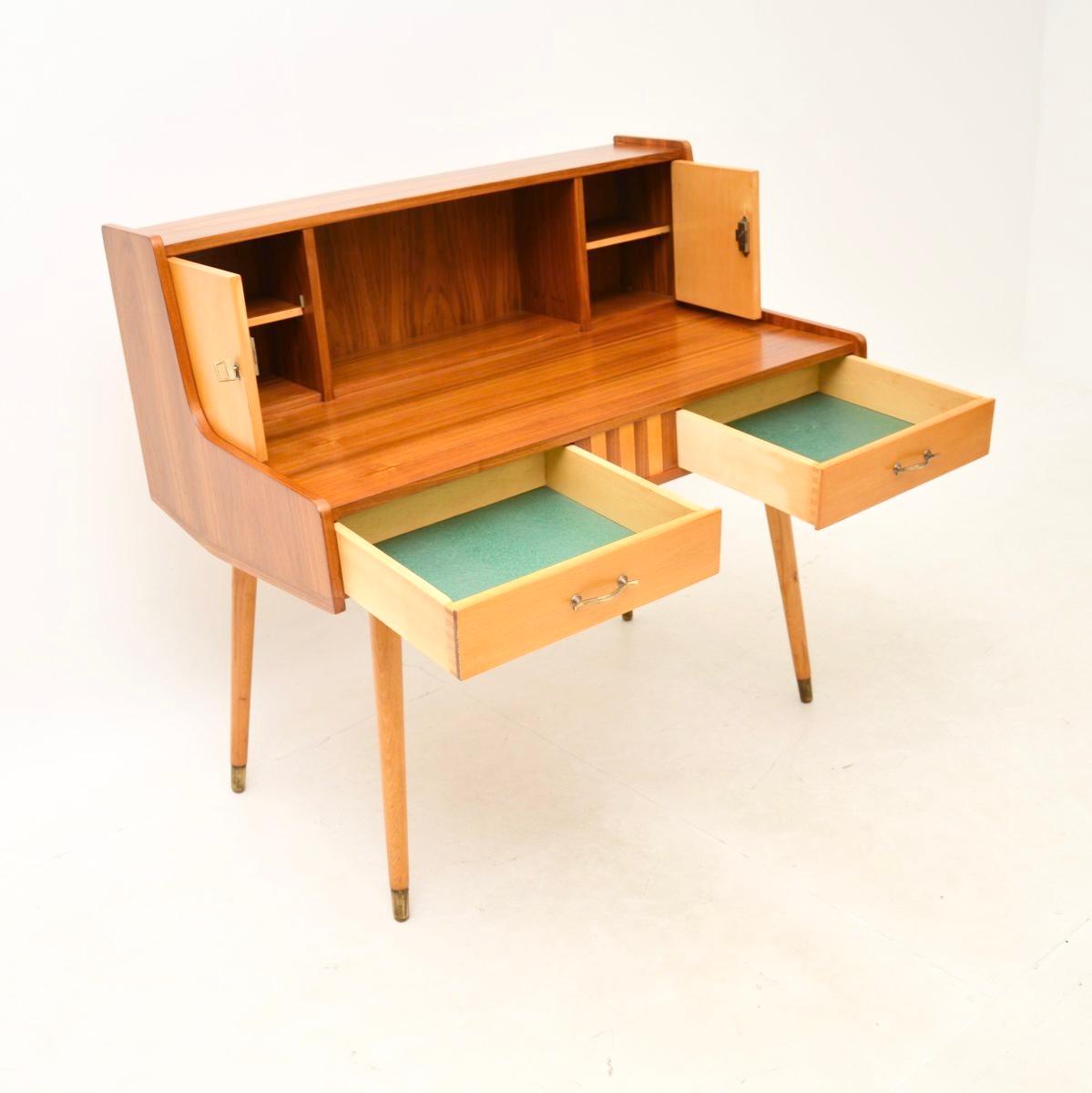 A superb vintage Italian walnut and satin wood desk, dating from the 1950-60’s.

It is beautifully designed and is of superb quality, standing on wonderful tapered legs with brass feet caps. There is lots of storage space in the lower drawers and