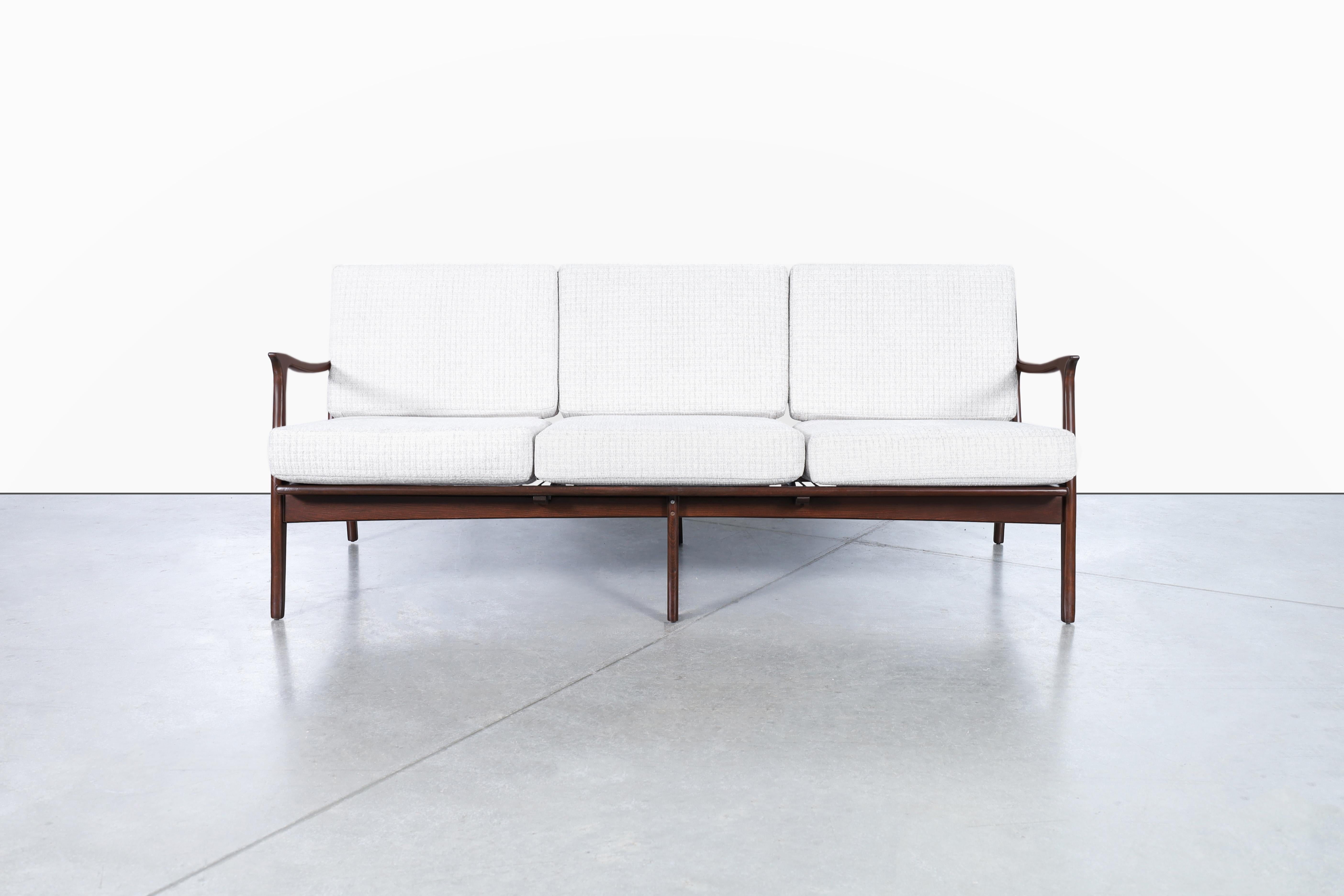This vintage walnut sculptural sofa manufactured in Italy is a true masterpiece that will elevate any living space to a whole new level of elegance. Handcrafted from high-quality walnut wood, the sculptural frame of this sofa is a true work of art