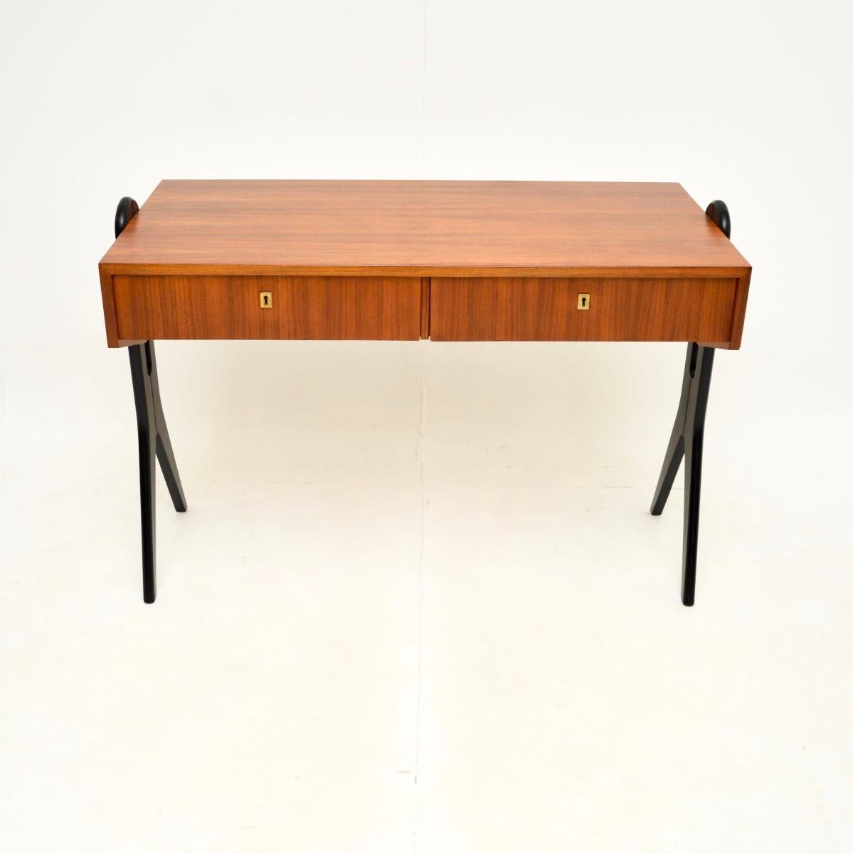 Un superbe bureau vintage en noyer italien, datant des années 1960.

Ce meuble est d'une superbe qualité, il est magnifiquement conçu avec de fantastiques pieds ébonisés en forme de compas. Il y a deux tiroirs avec une clé pour chacun d'entre eux.