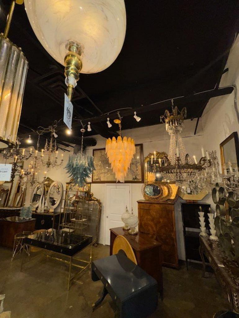 This Vintage Italian Waterfall Two Tone Murano Glass Chandelier is an exquisite lighting fixture with a luxurious design and craftsmanship. Made of glass, it features a stunning waterfall design that adds elegance and sophistication to any space.