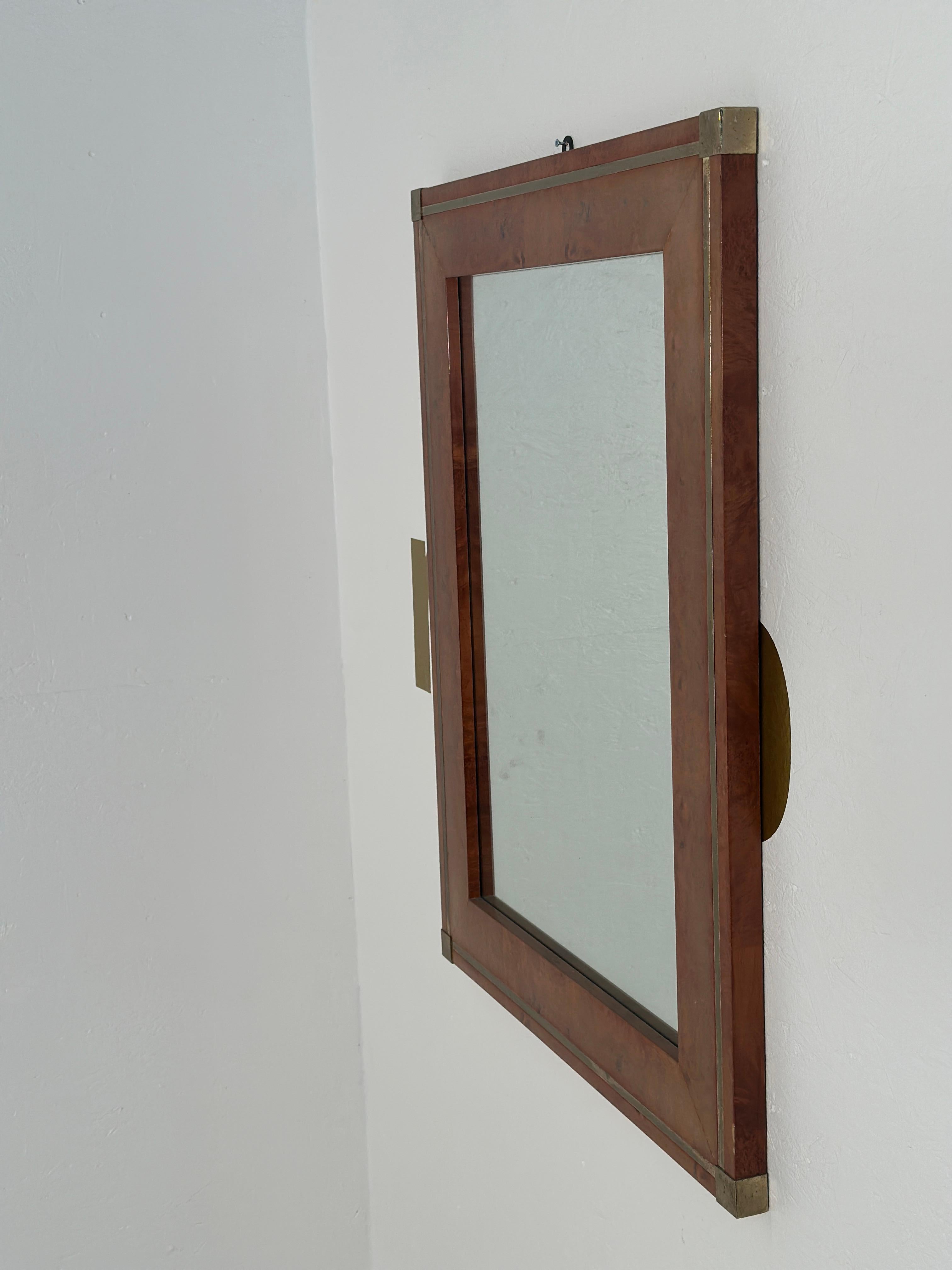 The Vintage Italian Wood & Brass Wall Mirror from the 1980s showcases a perfect blend of wood and brass, with original patina enhancing its charm. This piece captures the essence of Italian craftsmanship and design flair from the era.

