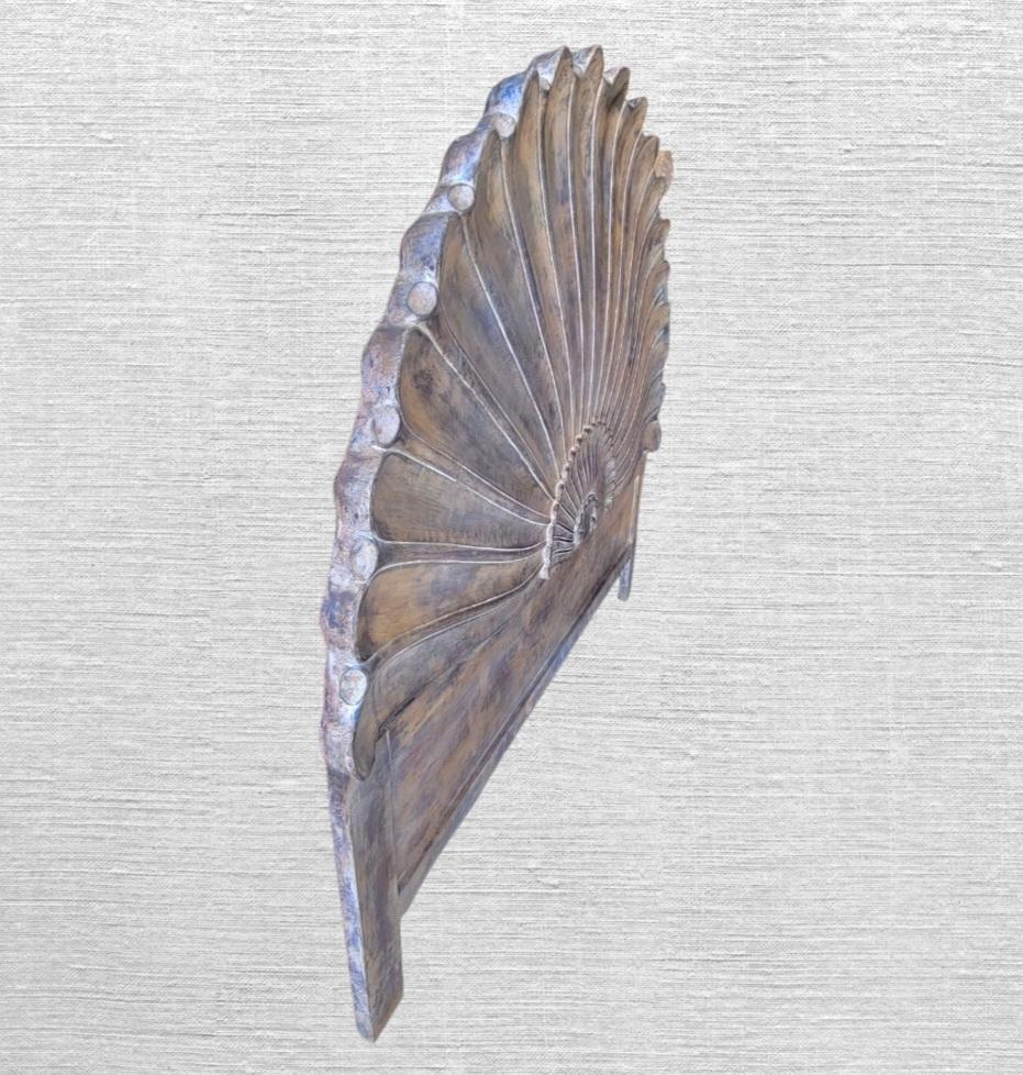 A wonderful solid carved wood Italian Regency shell firm carved headboard. The headboard features an extremely heavy solid wood construction in a beautiful seashell carved form. The finish has a slight rustic faux surface with tones of browns, tans