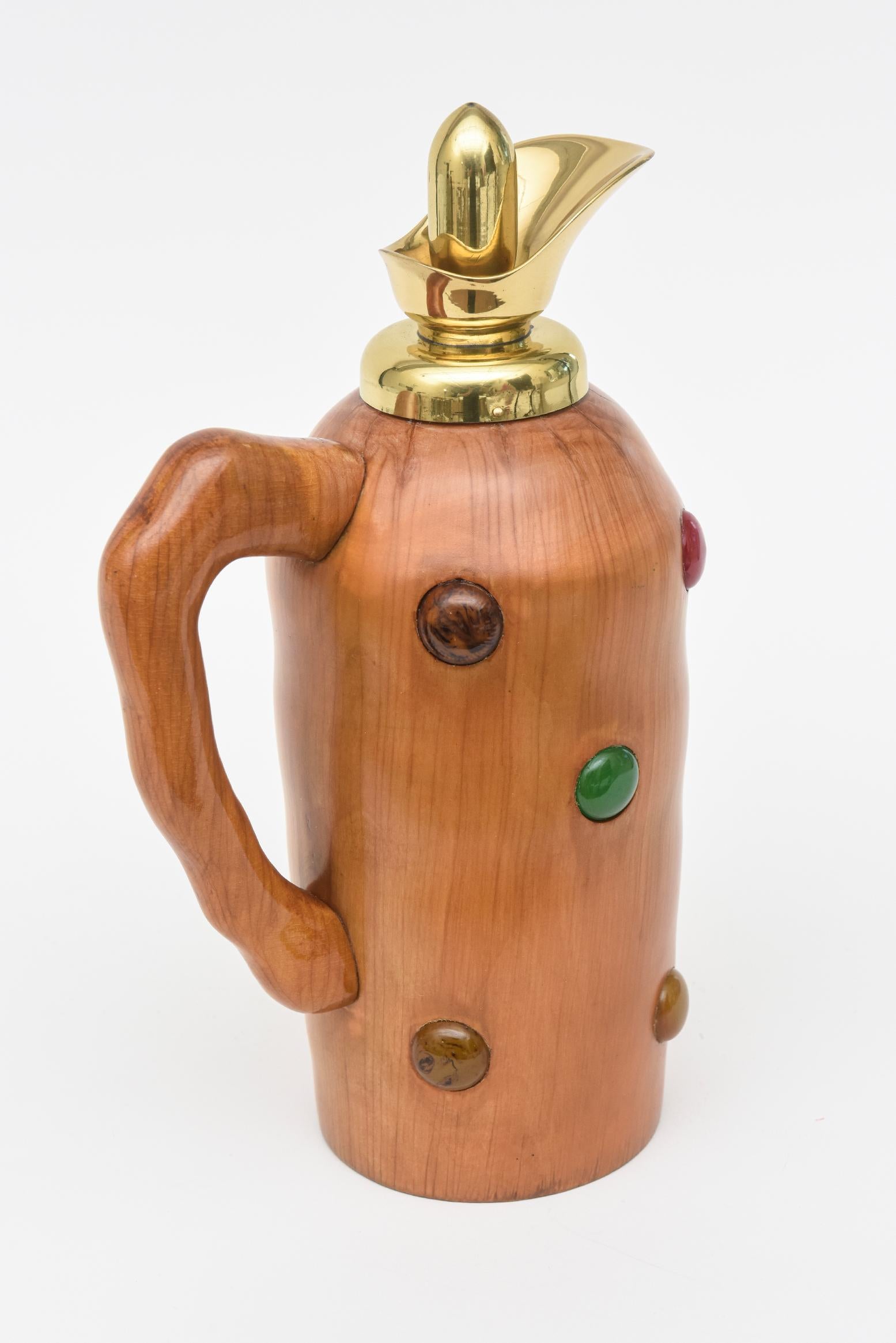 This mid century modern Italian jug is in the style of Aldo Tura. it is a beautiful wood with interspersed dots of colored resin throughout the body of  the colors of brown, red, green, tan There are markings on the bottom not exactly legibile but