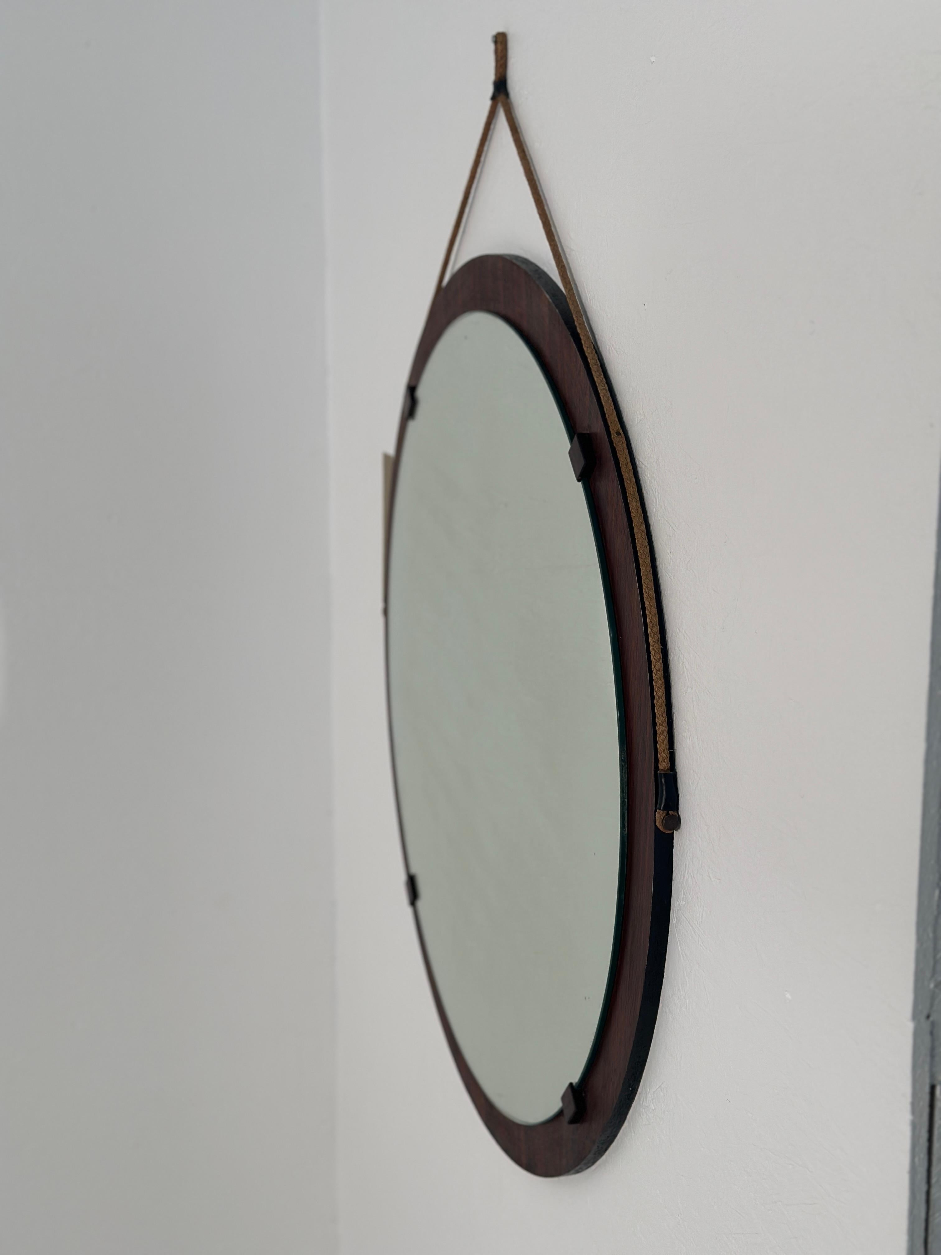 The Vintage Italian Wood Round Wall Mirror from the 1980s is a charming piece featuring a circular design with a wooden frame, epitomizing the rustic elegance of Italian craftsmanship from that era.


