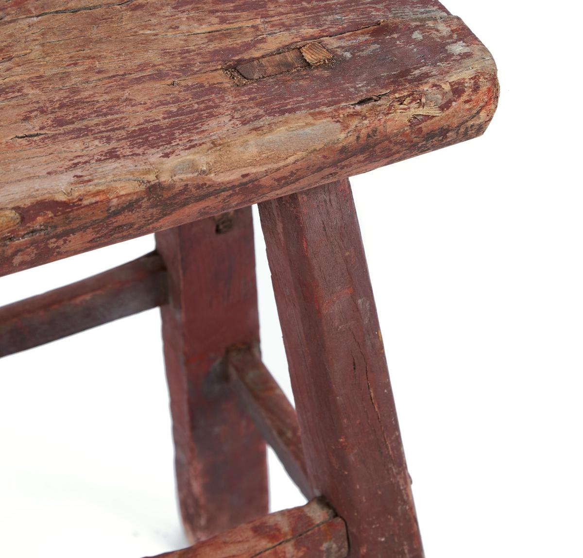 Vintage wooden stool in faded red. This piece is originally from Italy and thought to be from the late 19th century. The distressed appearance of the wood gives to this piece a very charming texture.