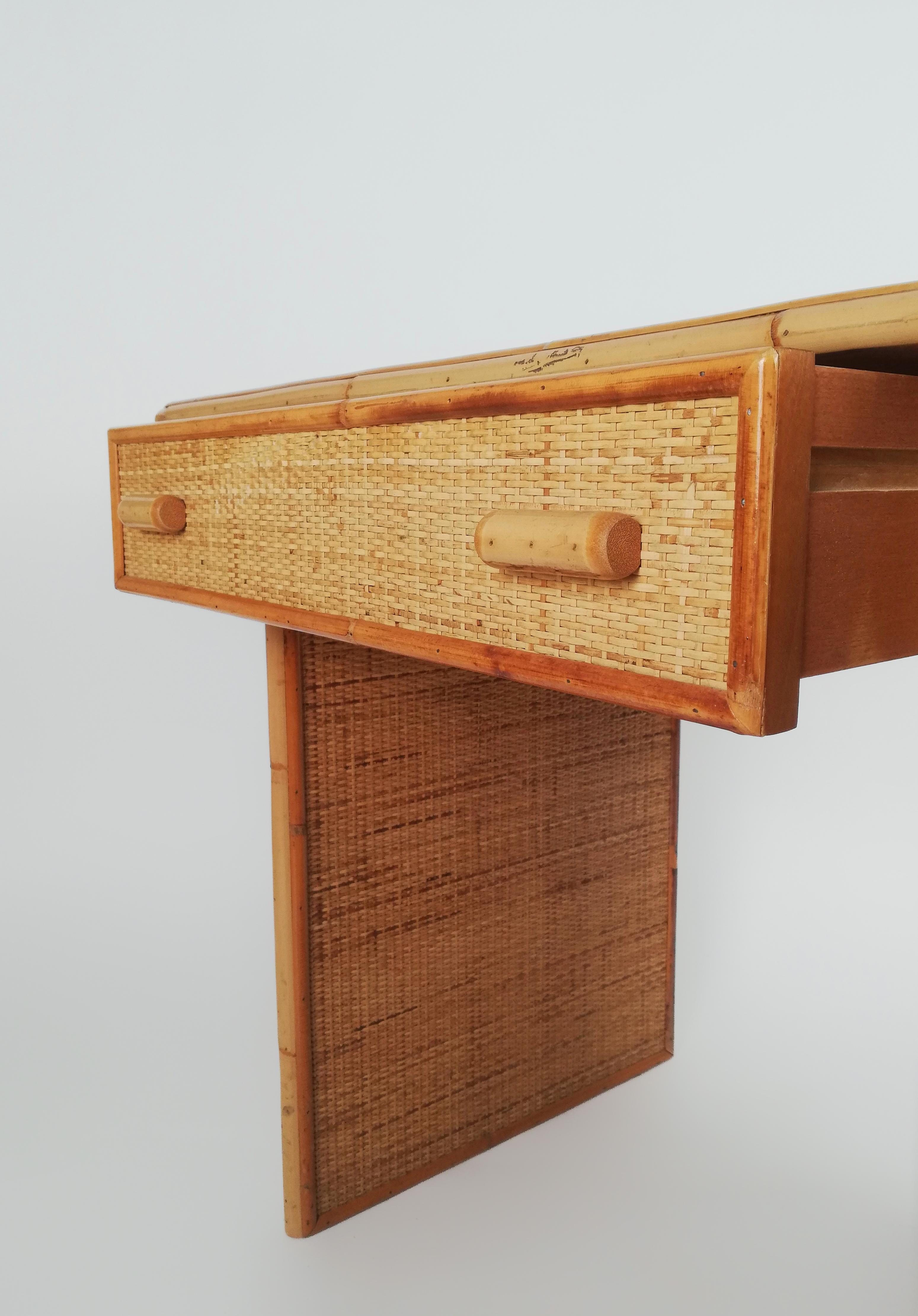 Ein Vintage-Schreibtisch mit Schubladen, der zwischen den 1960er und 1970er Jahren in Italien hergestellt wurde.
Dieser Schreibtisch hat eine solide Struktur aus Eschenholz und Sperrholz, die mit einer dicken Textur aus geflochtenem Rattan und