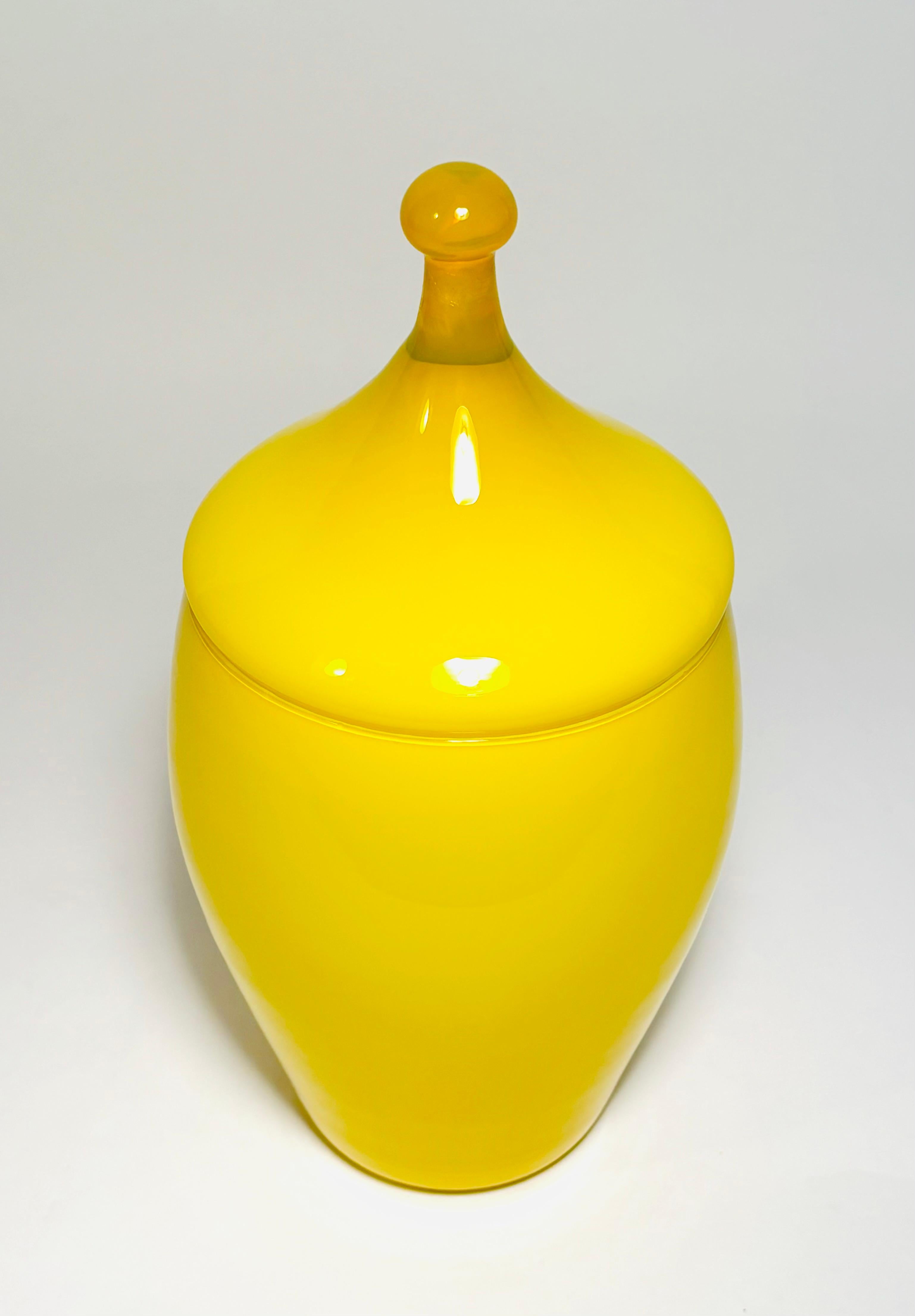 Vase en verre soufflé jaune soleil avec couvercle. Réalisée par l'un des souffleurs de verre de Florence (Italie), cette pièce est joliment moulée et peut être utilisée comme vase. En très bon état vintage.