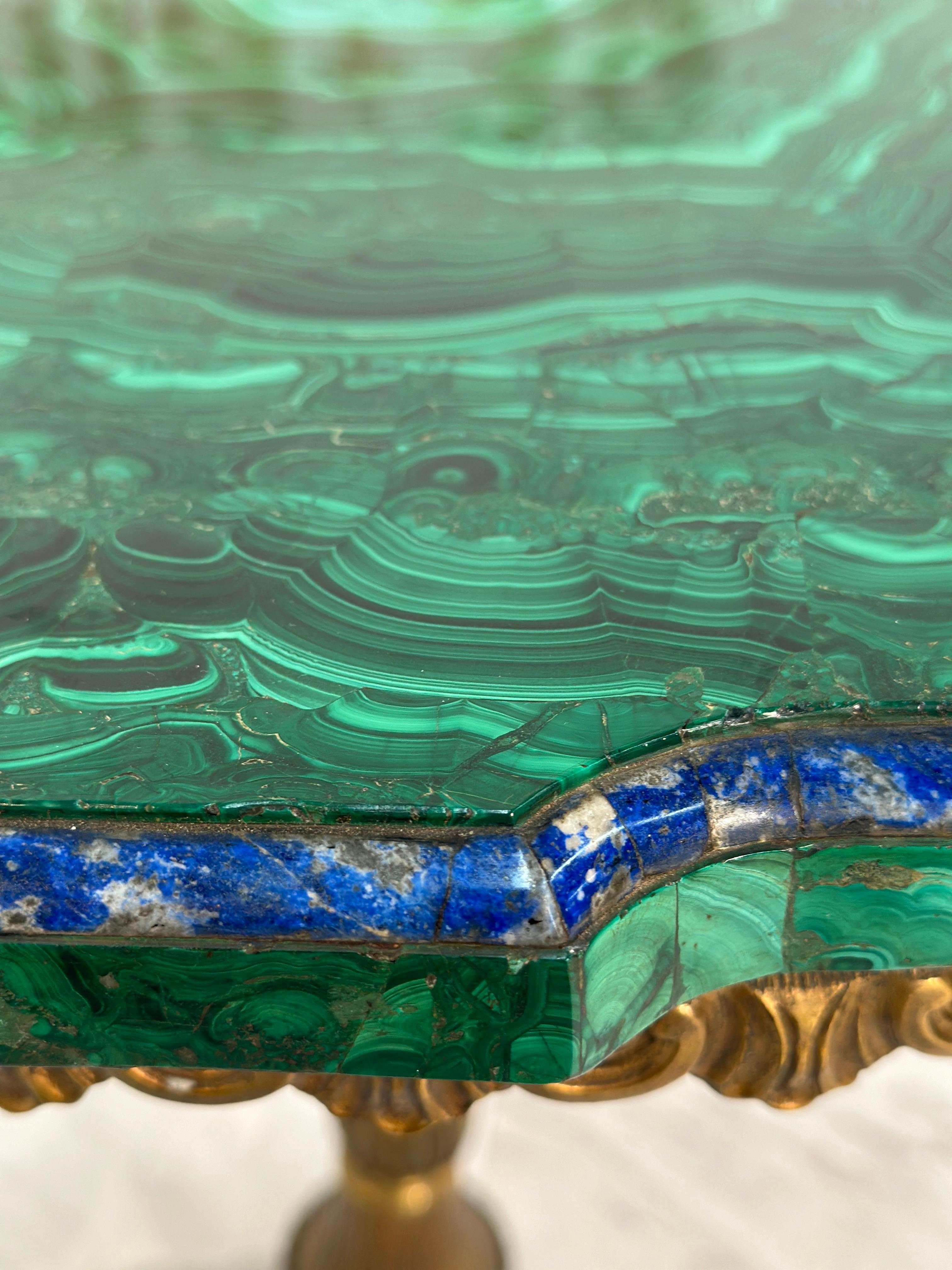 The Vintage Italian Brass and Malachite Stone Side Table from the 1940s exudes opulence and sophistication. Crafted with exquisite Italian craftsmanship, the table features a lustrous brass base complemented by the rich green hues of malachite