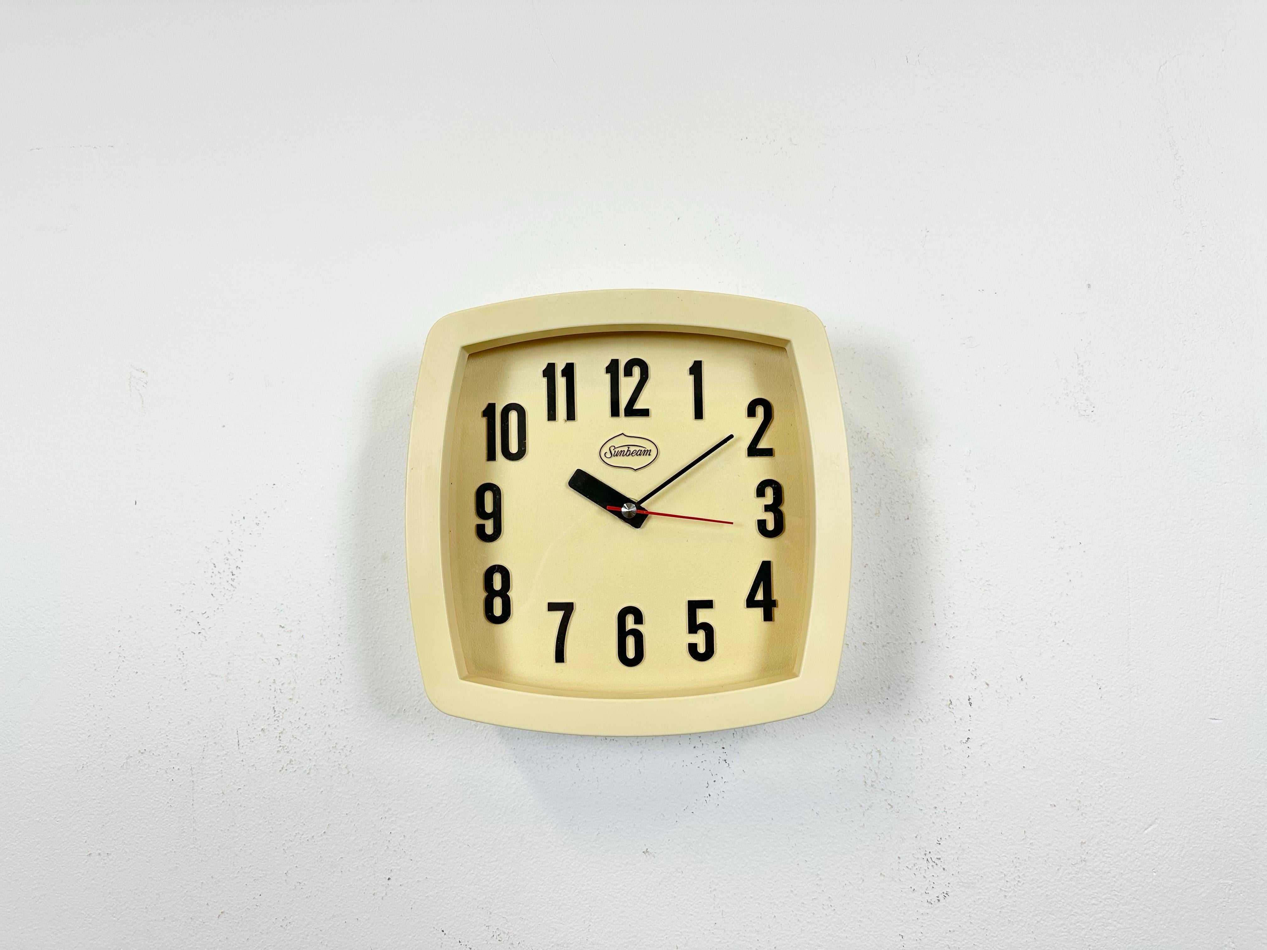 Vintage industrial wall clock produced by Sunbeam in Italy during the 1970s. It features a beige bakelite body, an aluminium hands and a clear glass cver. The piece has been converted into a battery-powered clockwork and requires only one AA-battery