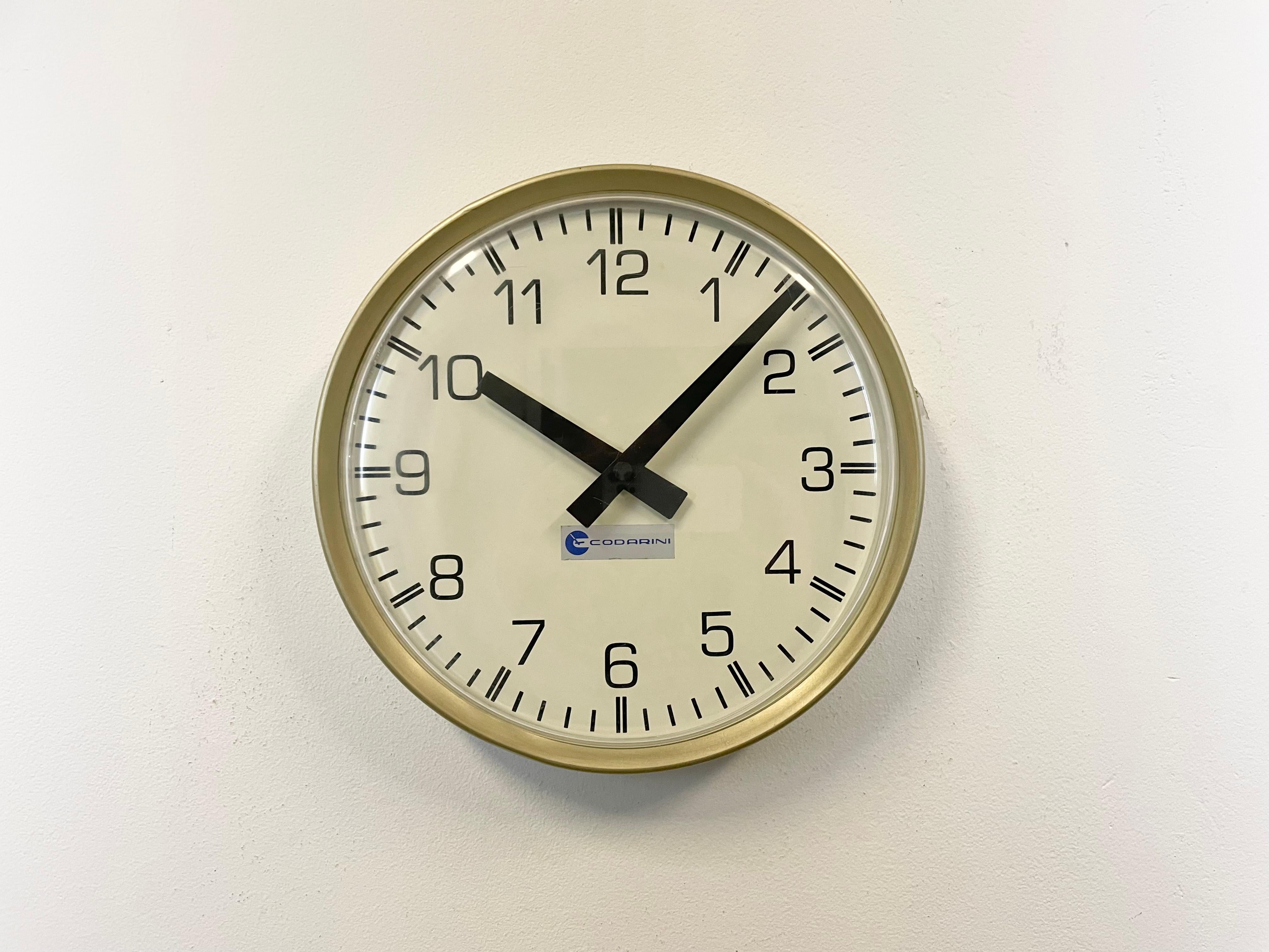 Wall clock produced by Codarini in Italy during the 1970s. It features an iron frame, an iron dial and a curved clear plexiglass cover. The piece has been converted into a battery-powered clockwork and requires only one AA-battery. Measures: