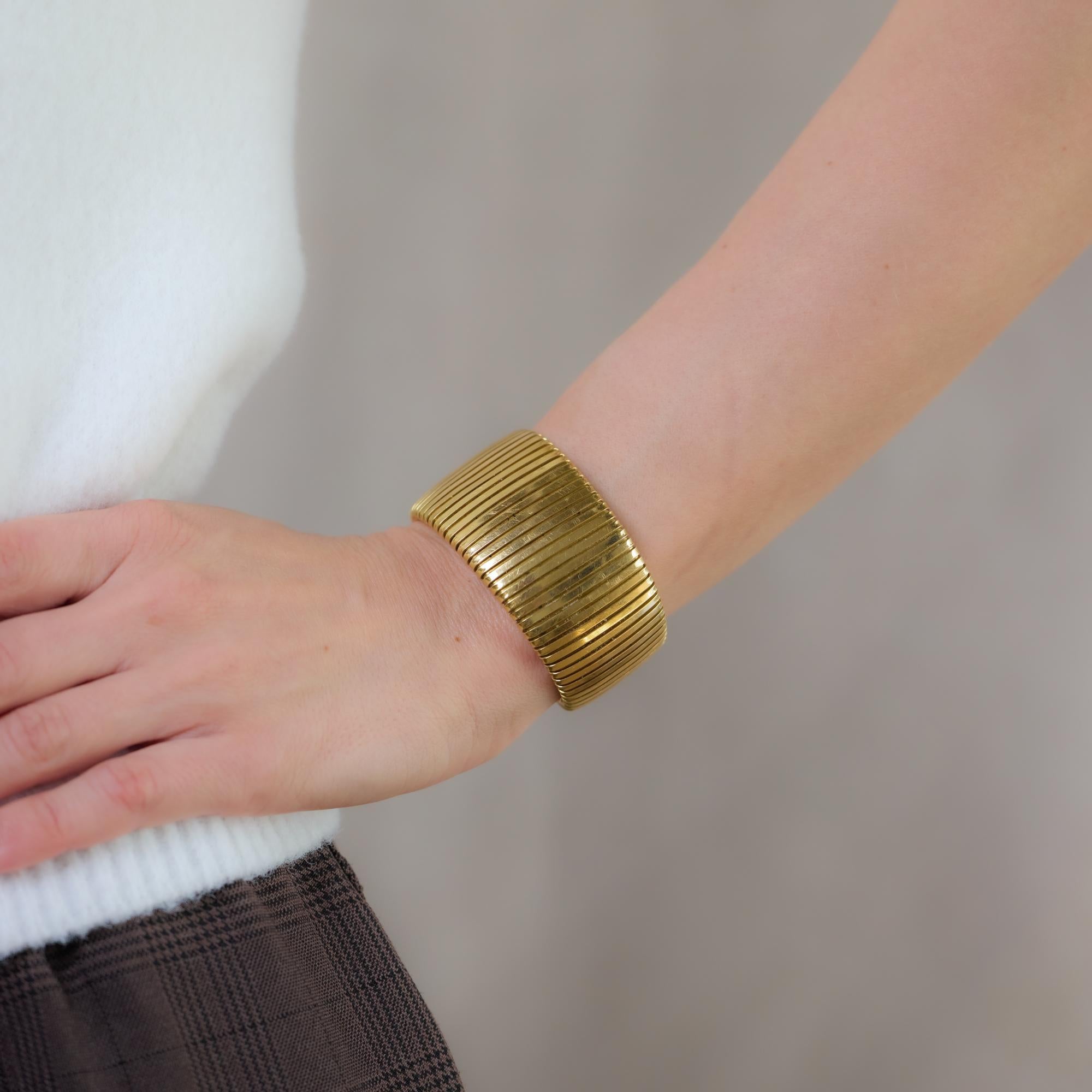 This vintage Italian 18k yellow gold Tubogas-style cuff bangle showcases an iconic, flexible coiled design, embodying timeless sophistication and craftsmanship. A bold yet elegant statement piece, it is hallmarked with Italy, a serial number,
