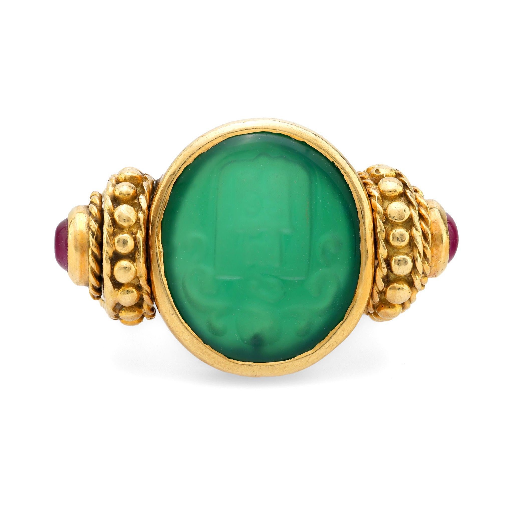 A vintage 1980s Italian-crafted ring featuring a beautifully carved chrysoprase centerpiece, accented by vibrant cabochon rubies, set in radiant 18k yellow gold.

Center stone: Carved chrysoprase 
Accent stone: 2 cabochon cut rubies
Metal: 18k