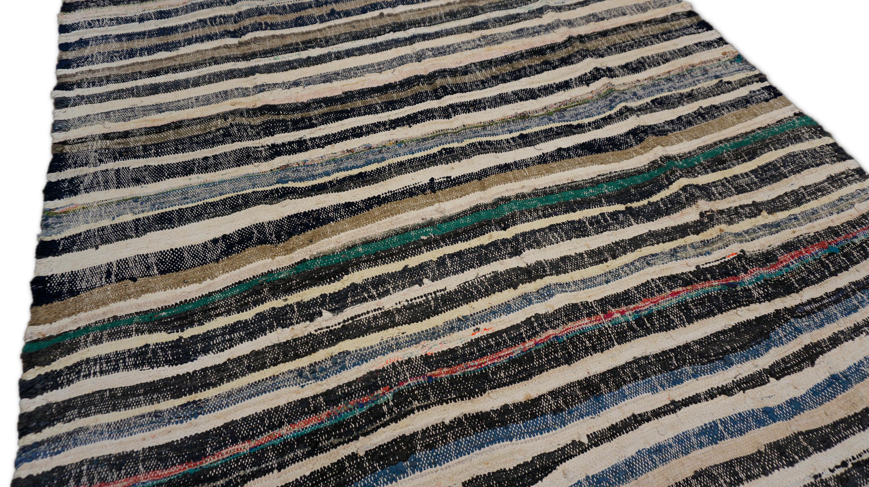 Questo kilim vintage in lana tessuto a mano cattura l'essenza dell'arte popolare minimalista con il suo ritmo lineare e la sua consistenza terrosa. Questo kilim è composto da strisce orizzontali in un'ampia gamma di colori neutri, avorio, carbone,