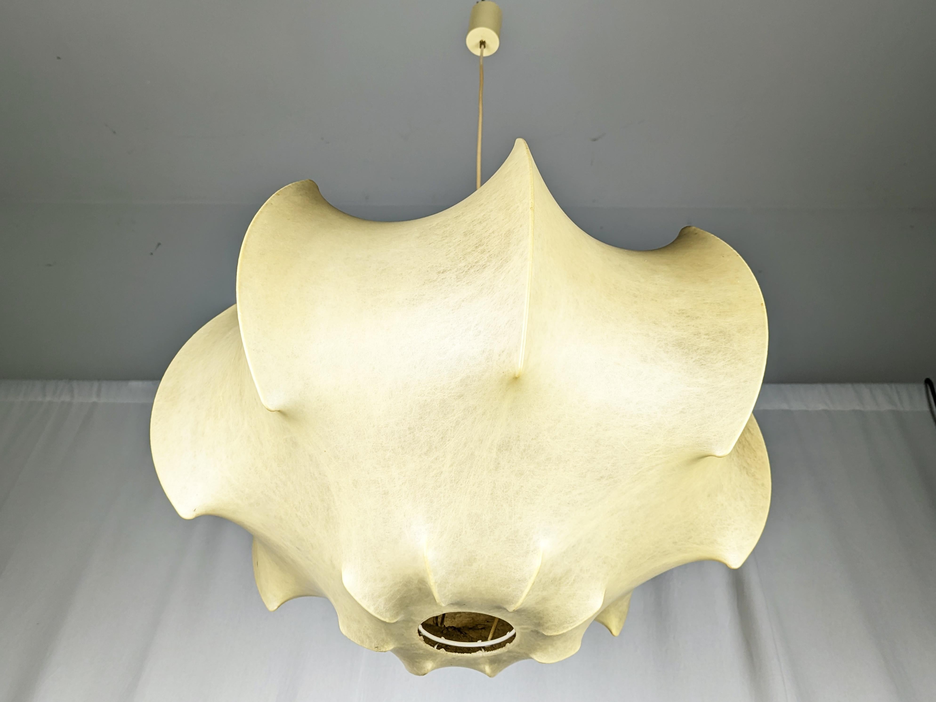 This pendant lamps named Viscontea, designed by Castiglioni Brothers in the early 1960s and produced by Flos.
The chandelier remains in pretty good overall condition: the yellowing of the cocoon is normal, consistent with the age of the