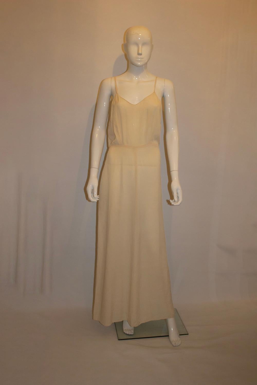 A  abito sottoveste vintage chic e sexy  (o camicia da notte) in seta color avorio. L'abito presenta un'apertura laterale con ganci e occhielli, spalline e scollatura a V.  davanti e dietro. 
Misure: Seno fino a 38'', lunghezza 59''.