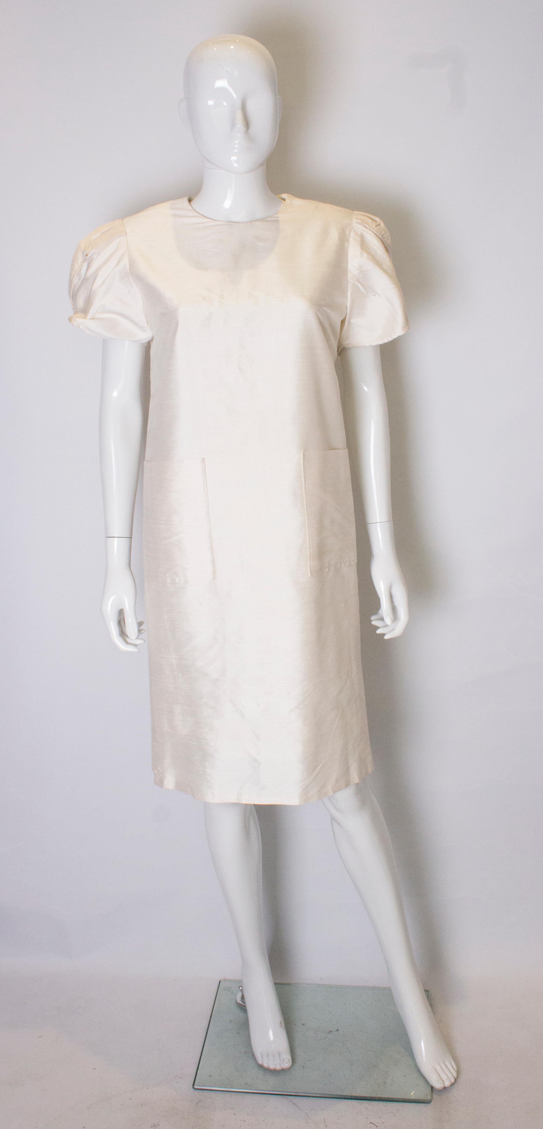 A great vintage raw silk shift dress.  The dress has wonderful sleeves, a button opening at the back and two pockets at the front. It has the original shoudler pads and is fully lined.