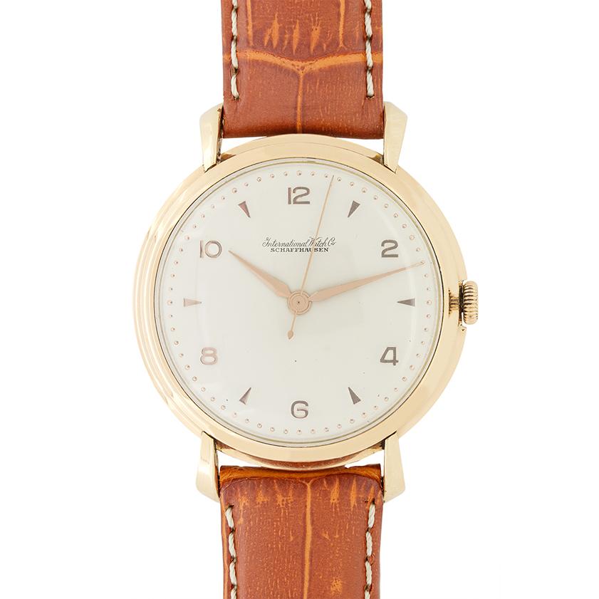 Questo bellissimo IWC  L'orologio risale agli anni '50. La cassa in oro giallo 18 carati misura 37 mm, con un bordo a gradini intorno al quadrante e anse a goccia che sorreggono il cinturino. I numeri arabi e i chevron indicano le ore in modo