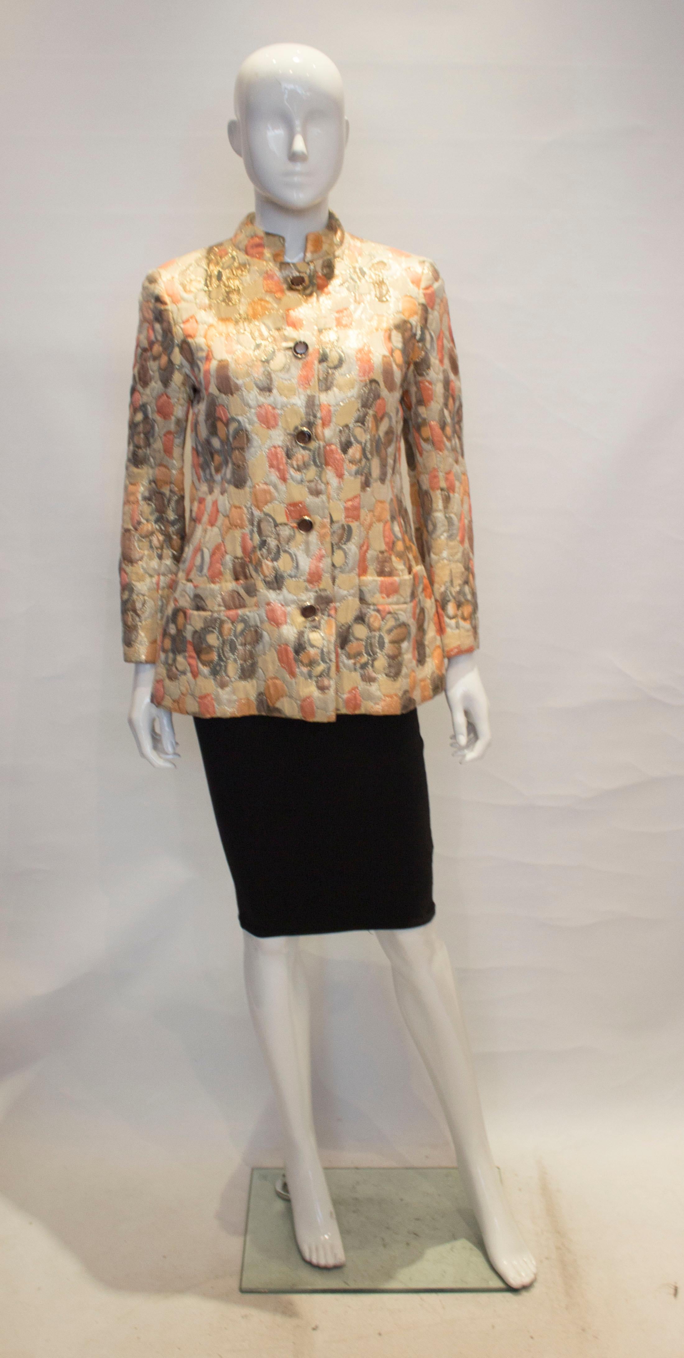 A chic  vintage jacket by J Tiktiner for Bergdorf Goodman. In a colourful slightly metallic mix of gold , rose, and grey , the jacket has a stand up collar, button front opening and pockets either side at hip leval. The jacket is fully lined.