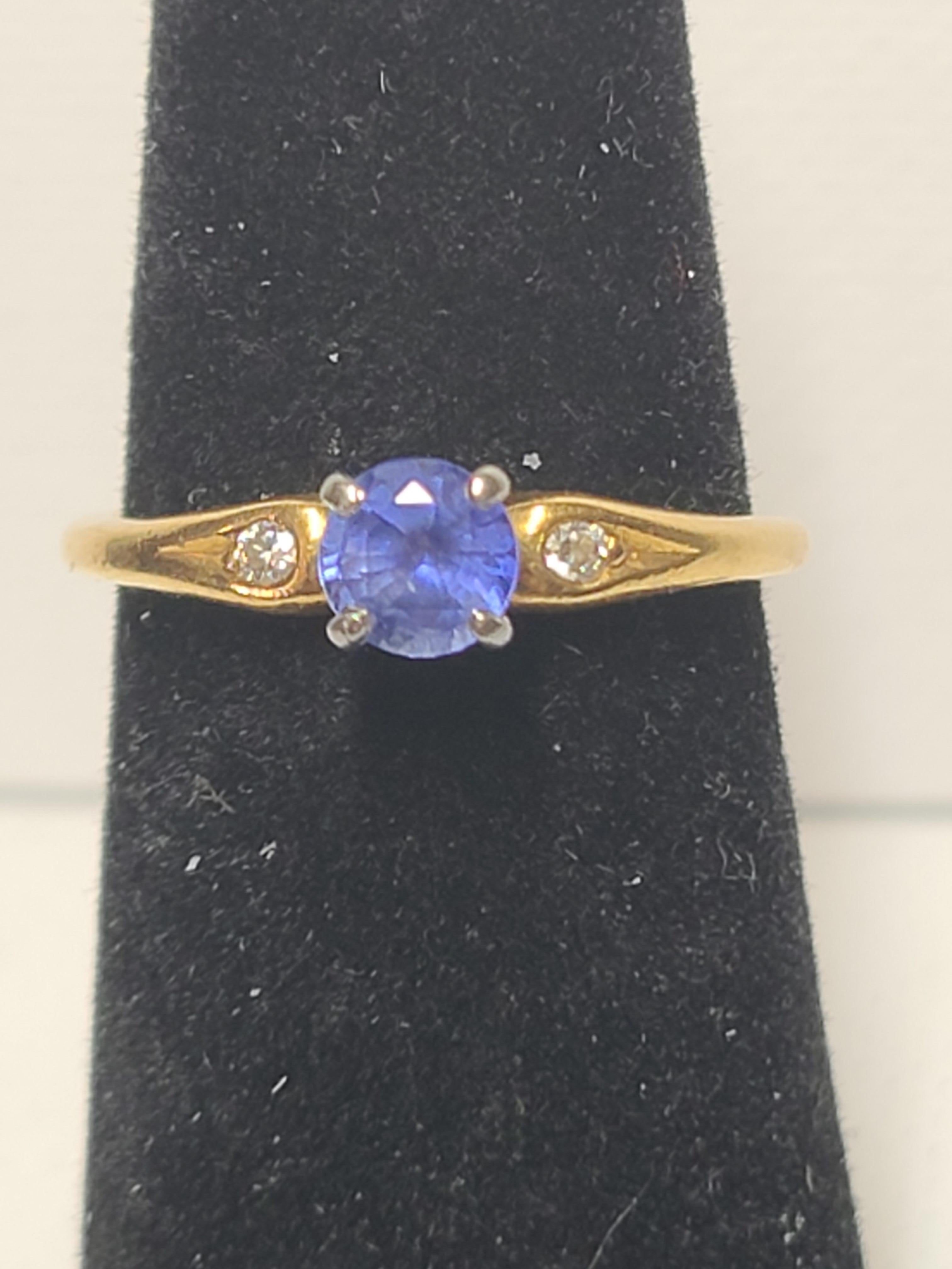This estate found vintage ring by Jabel is set in 18K Yellow Gold featuring a 4.7mm round cut sapphire set in a platinum head with diamond accents on each shoulder. 
The ring is size 6 (US) and weighs 2.9 grams.