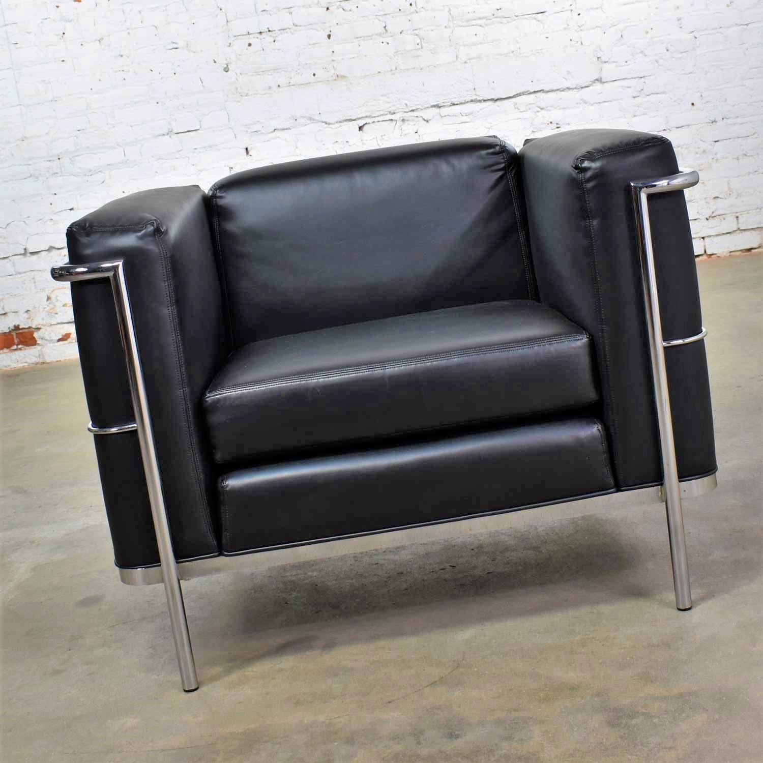 Handsome 20/123 black faux leather cube club chair by Jack Cartwright after Le Corbusier’s LC2 chair. This chair is in wonderful vintage condition. We have re-colored the faux leather to make it look brand new. The chrome may have some small