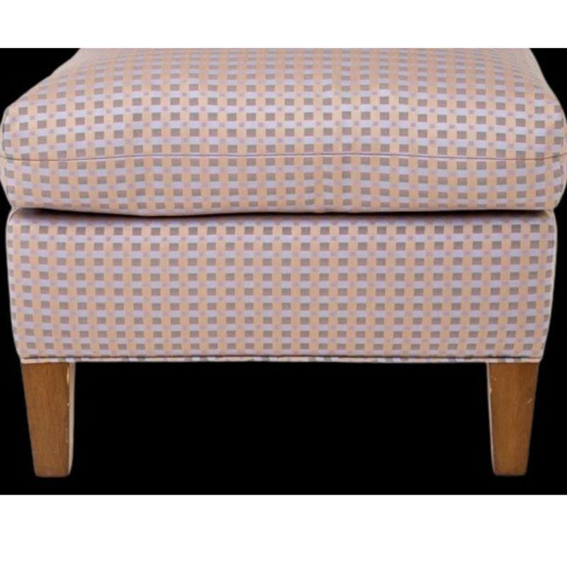 Mid-Century Modern upholstered slipper chair from Jack Lenor Larsen in geometric print with rectangular back and loose cushions. Upholstered in shades of gray and blue squares on a pale pink ground. Sits on tapered, square wood feet.