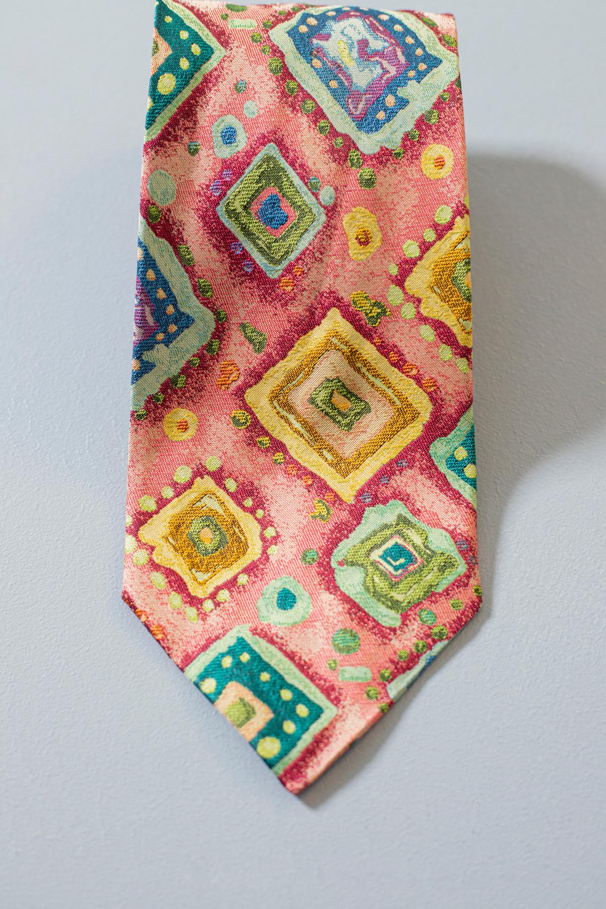 Questa eccentrica cravatta disegnata da Jack Rose di Palm Beach, Miami, è realizzata interamente in seta. Questa cravatta è estremamente decorata con motivi geometrici dai colori caldi ed estivi. Se vuoi un look particolare ma allo stesso tempo