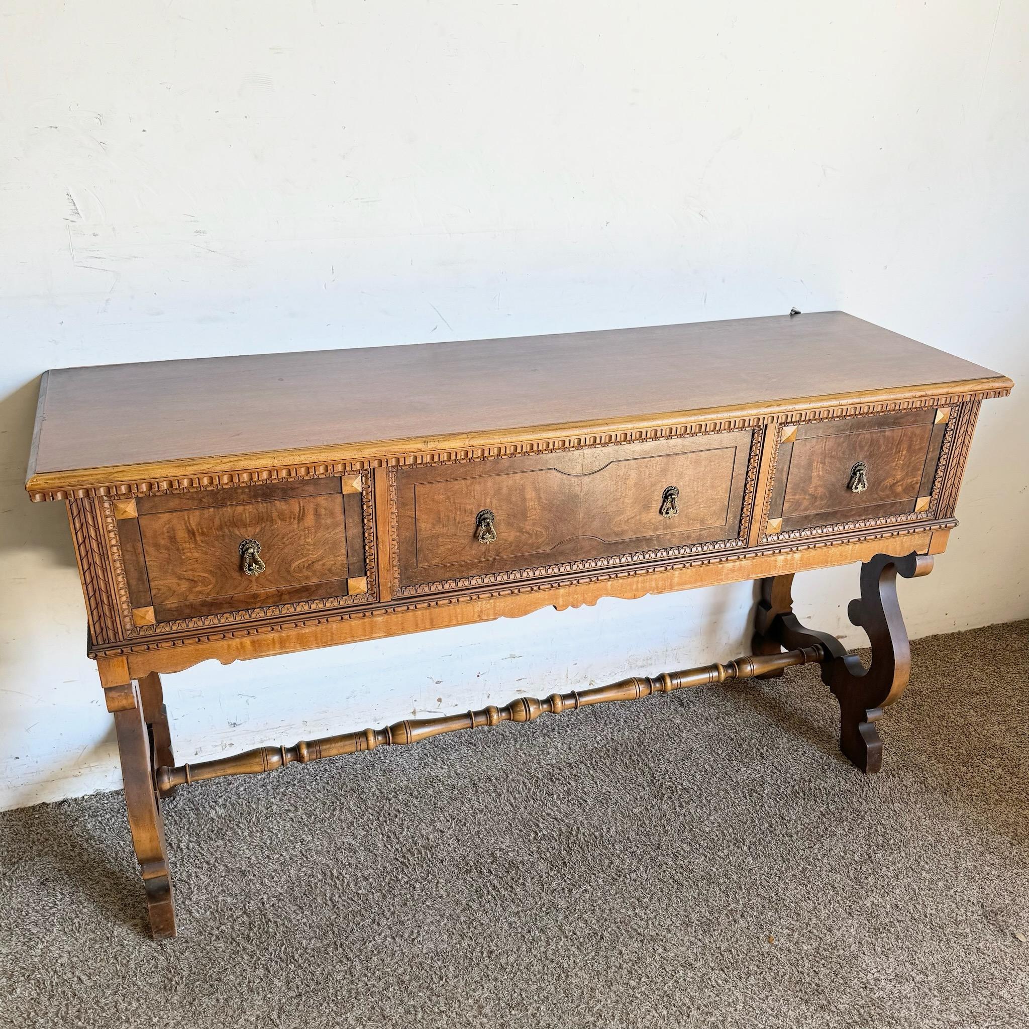 Questa credenza vintage in stile Jacobean è caratterizzata da un ricco legno di noce e radica con intricati dettagli intagliati. La sua silhouette elegante e i cassetti spaziosi la rendono perfetta per riporre gli oggetti essenziali per la tavola o